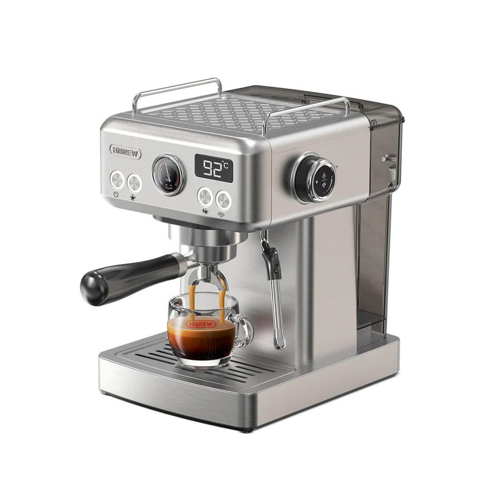 Una máquina de espresso plateada prepara café en una taza de vidrio. Pantalla digital muestra 92°C.