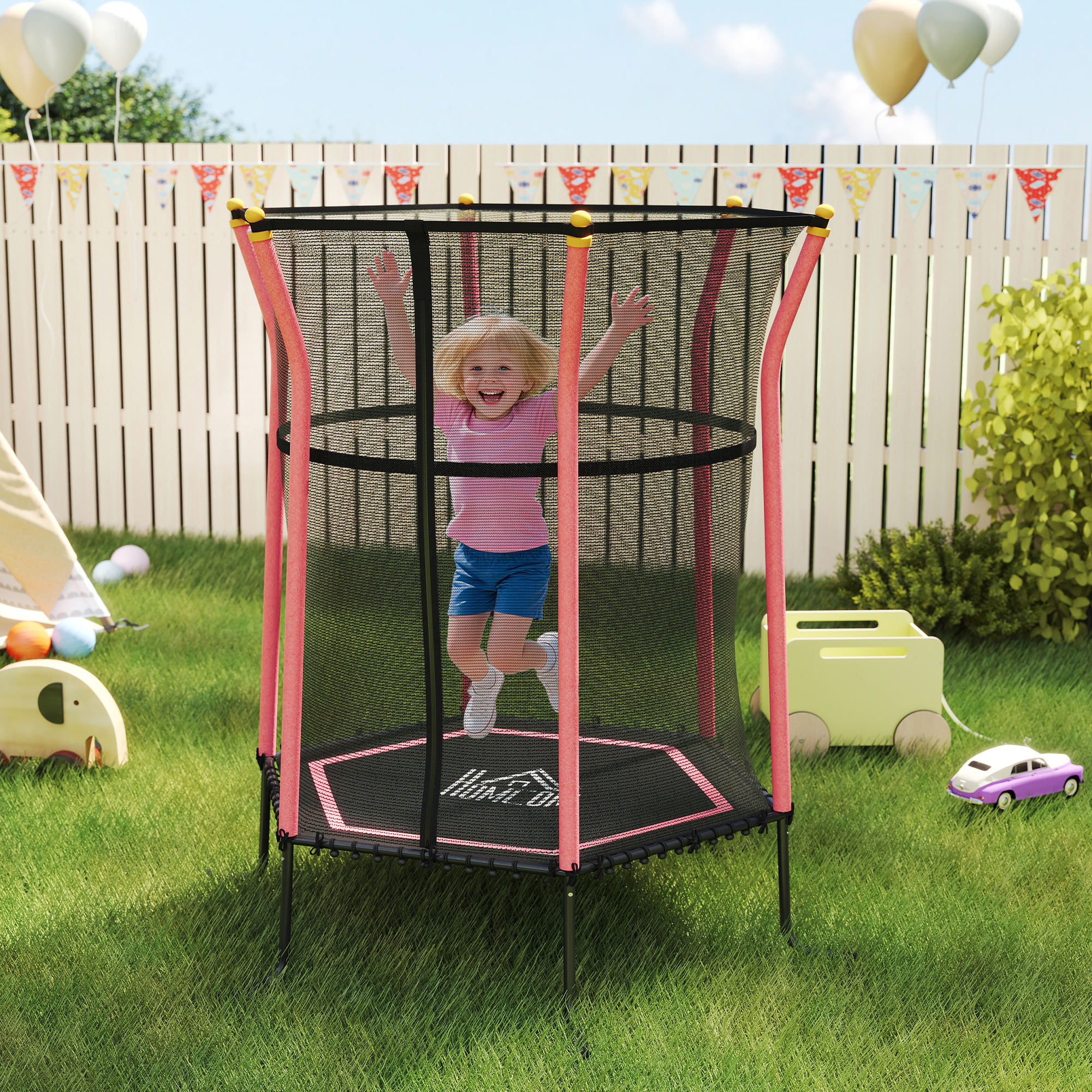 Una bambina felice salta su un trampolino in un cortile con giocattoli e palloncini.