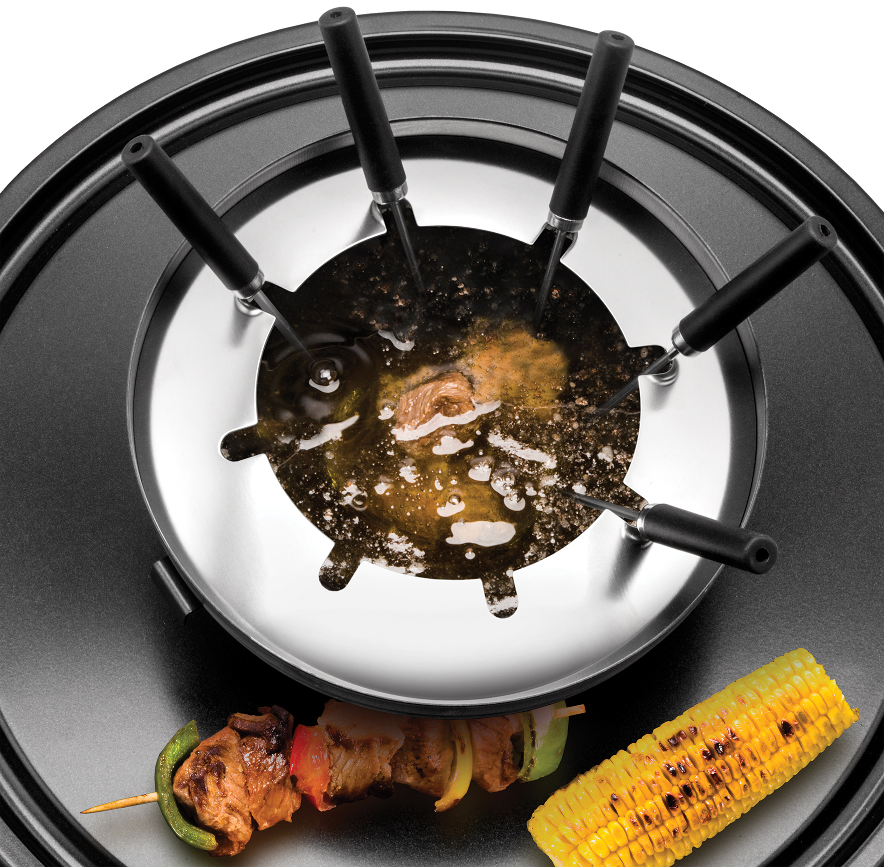 Ein Fonduetopf mit brodelndem Öl, Fleischspieß und Maiskolben.