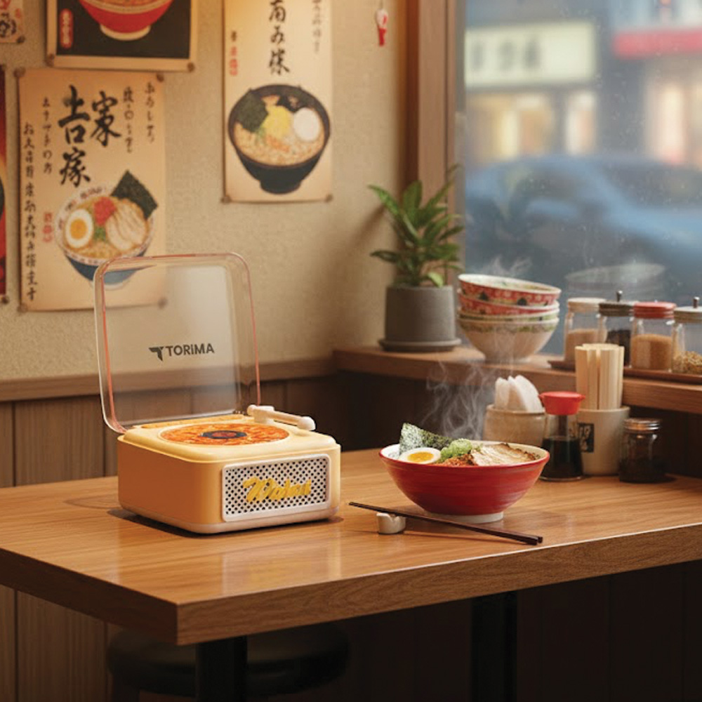 Buharlı bir kase ramen, retro bir pikabın yanında ahşap bir masada duruyor.