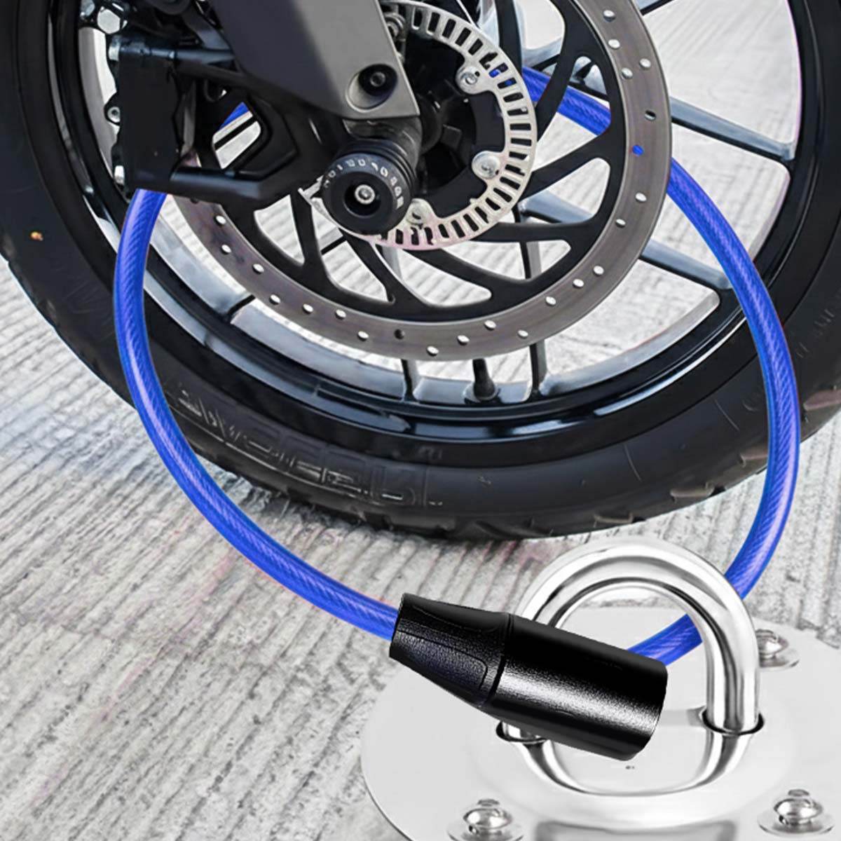 Ein blaues Kabelschloss sichert ein Motorradrad an einem Metallanker auf Beton.