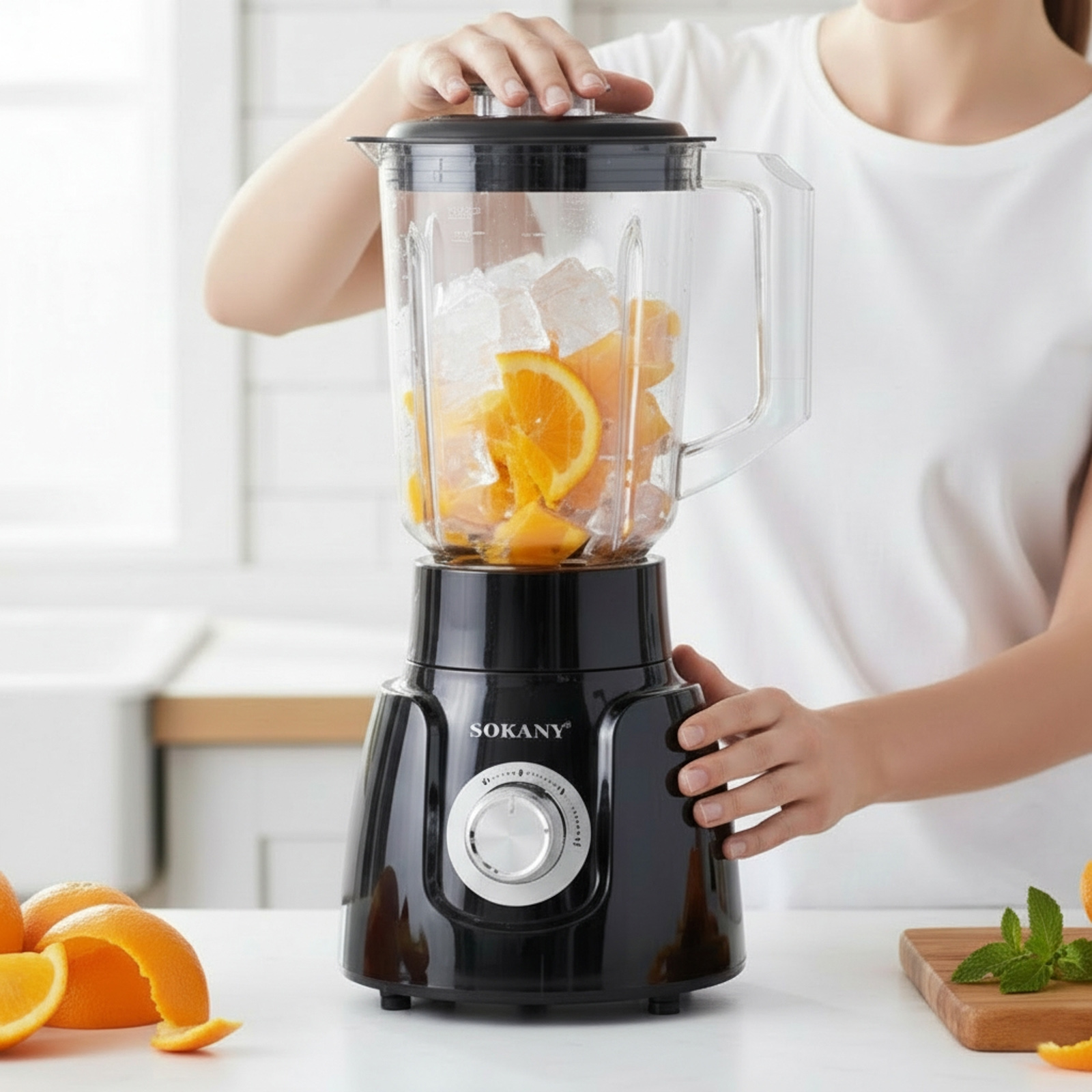 Una licuadora negra con naranjas y cubitos de hielo se prepara para licuar.