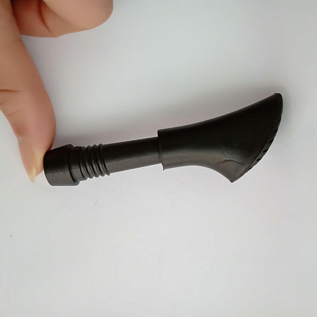 Czarny plastikowy uchwyt z żebrami i zakrzywioną końcówką.