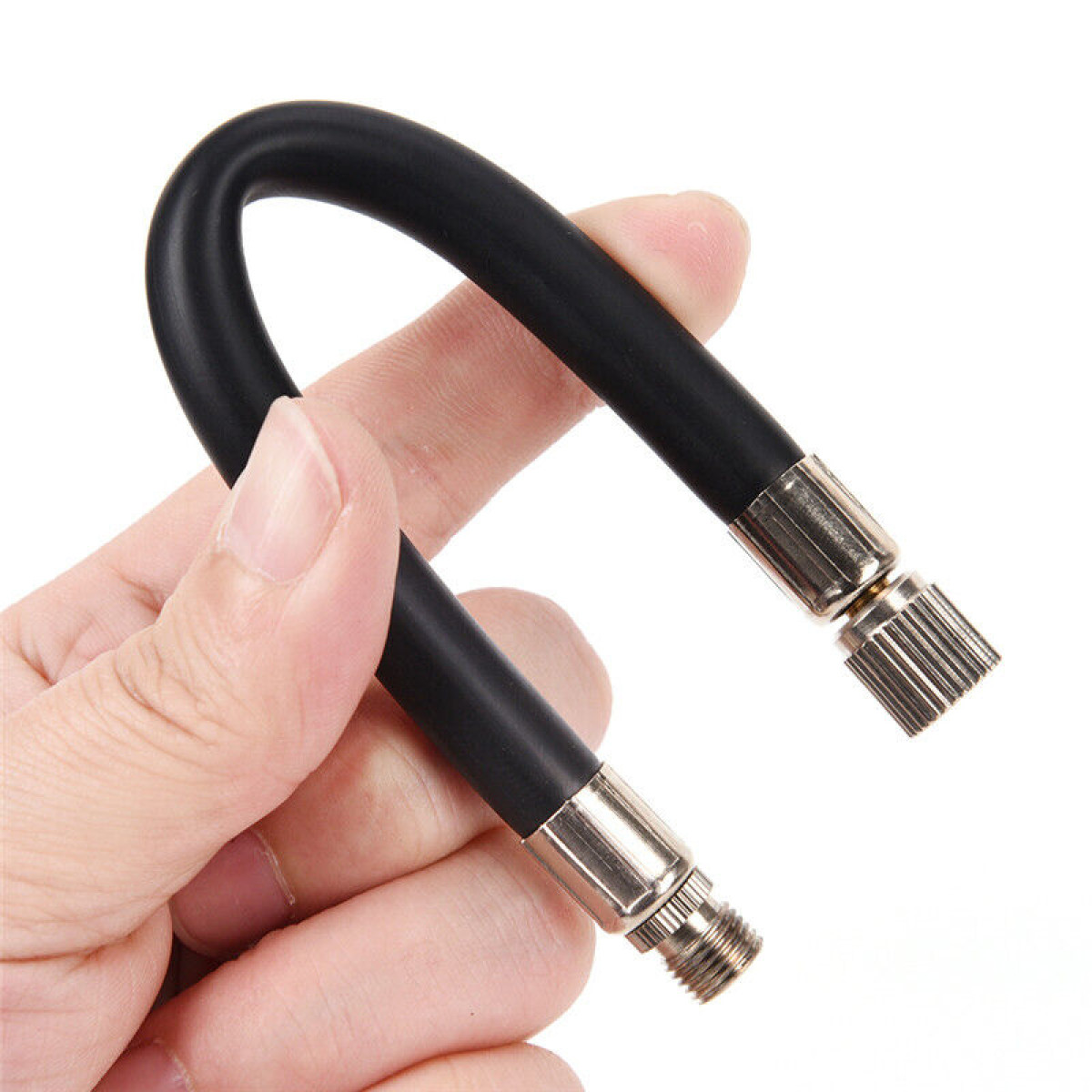 Czarny wąż z metalowymi złączkami trzymany jest przez rękę.