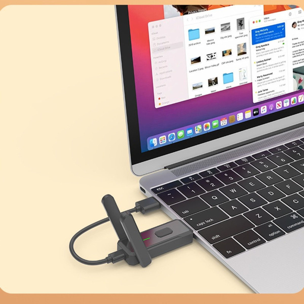 Ein Laptop zeigt iCloud Drive-Dateien. Ein USB-WLAN-Adapter ist am Laptop angeschlossen.