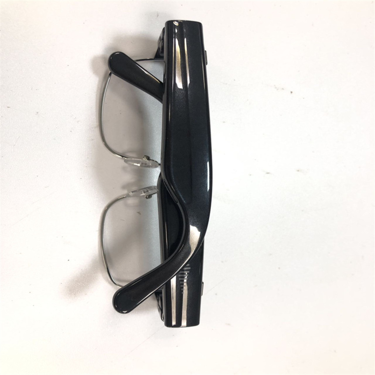 Czarna para okularów do czytania złożona na białej powierzchni.