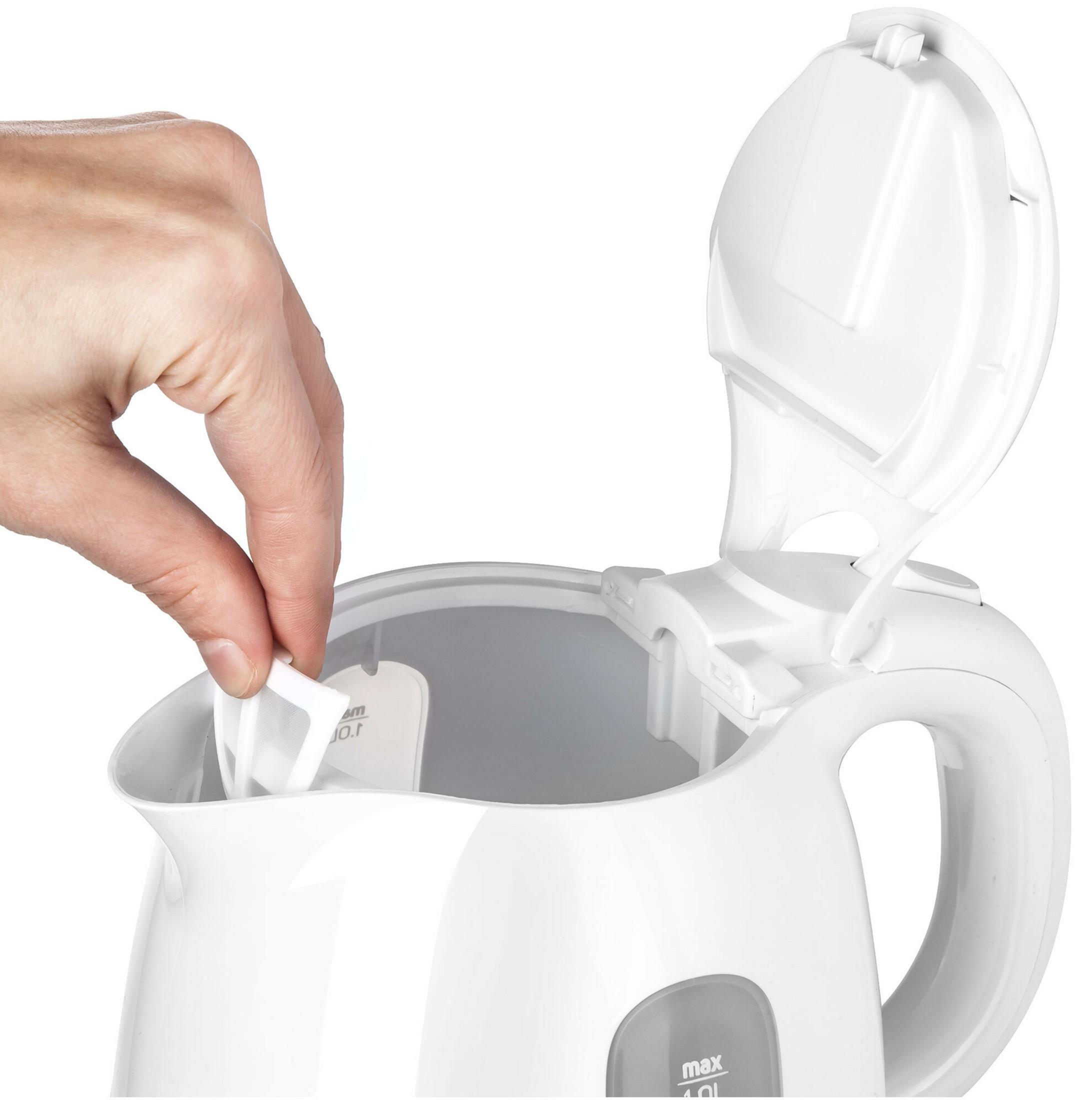 Ręka wkłada biały filtr do otwartego białego czajnika elektrycznego.