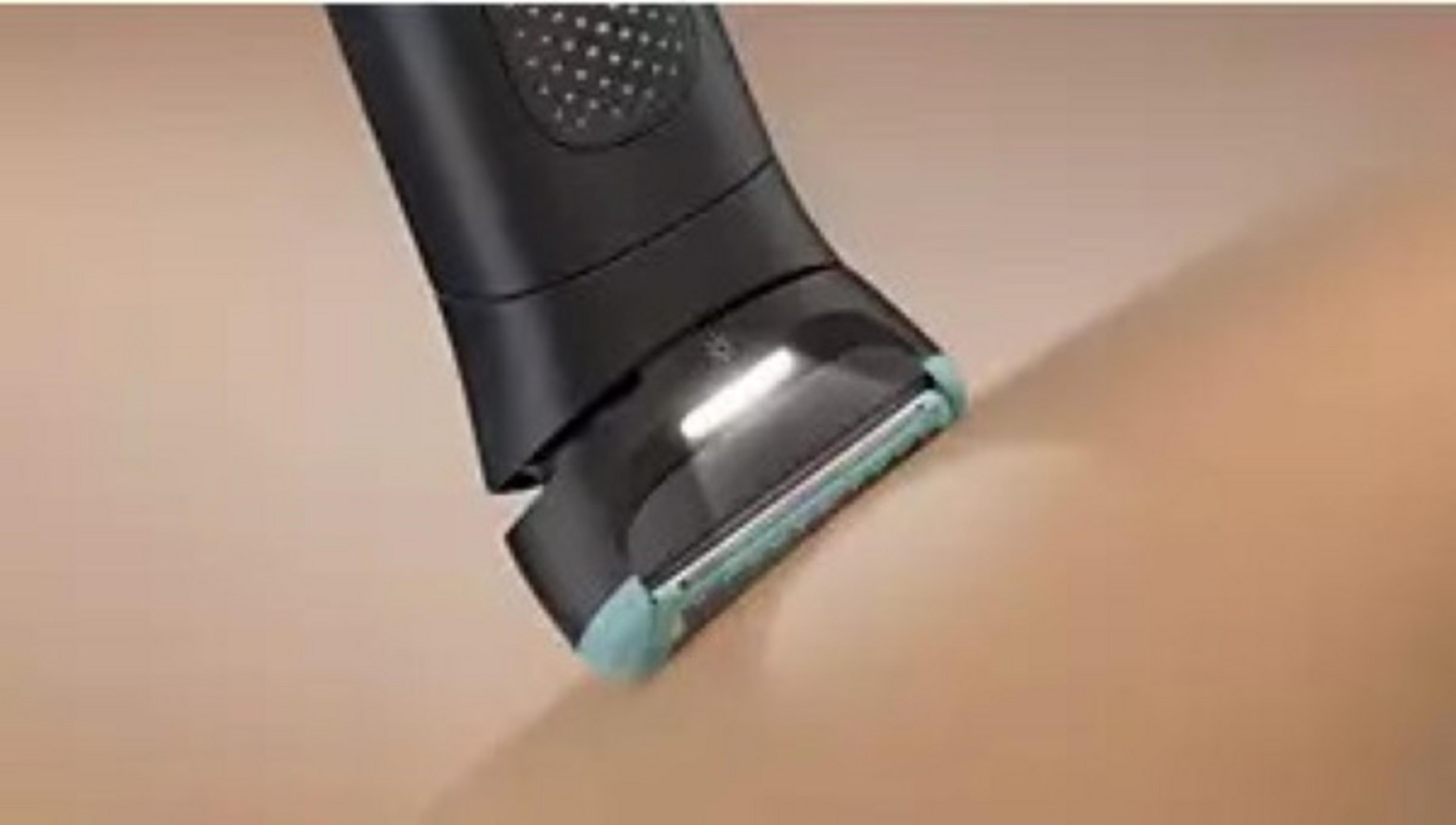 Czarna elektryczna golarka z podświetlanym ostrzem przycina skórę.