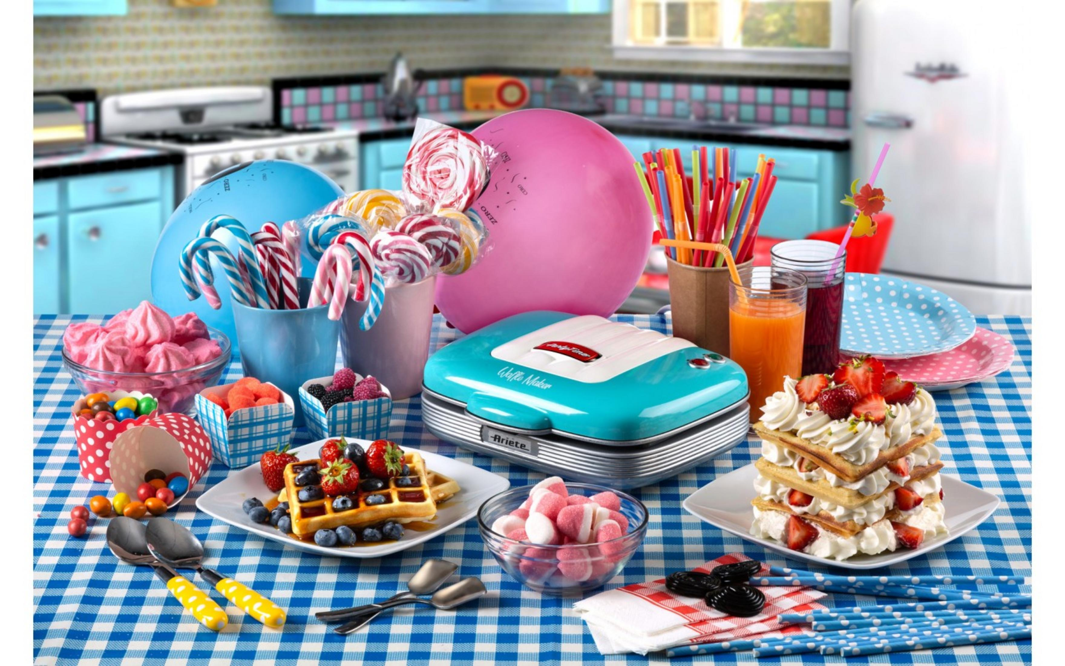 Snoep, wafels en drankjes gerangschikt op een blauw geblokt tafelkleed.