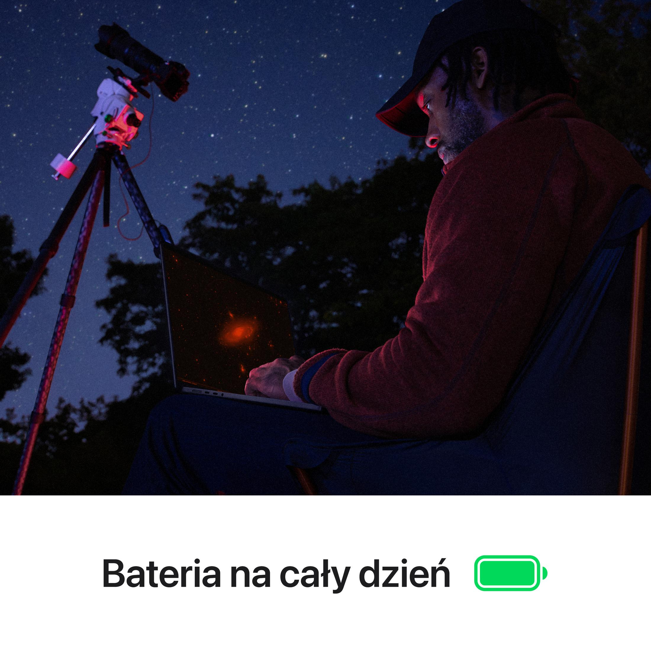 Mężczyzna z teleskopem i laptopem pod rozgwieżdżonym niebem.