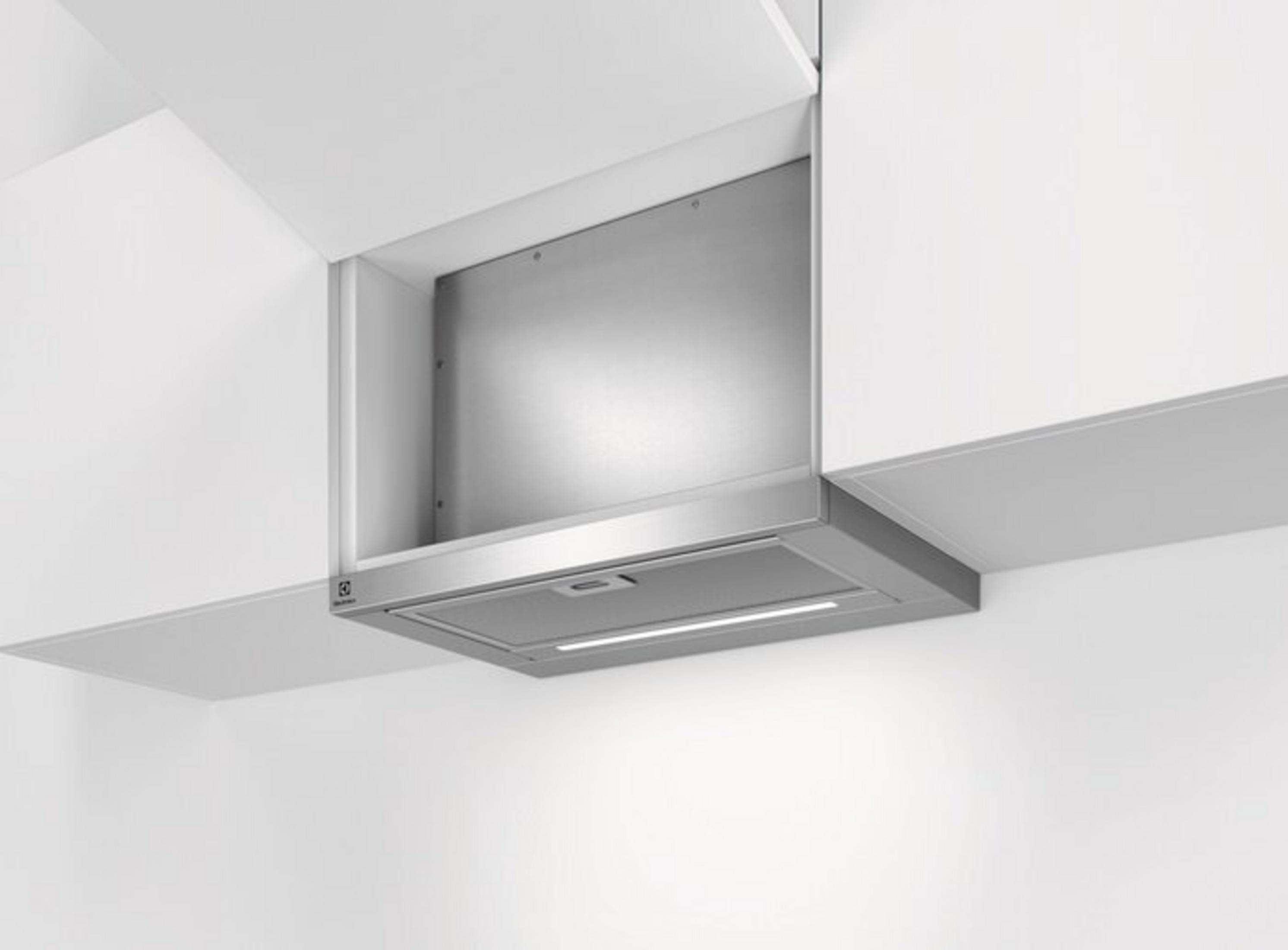 Cappa aspirante in acciaio inox all'interno di un mobile da cucina bianco con illuminazione a LED.