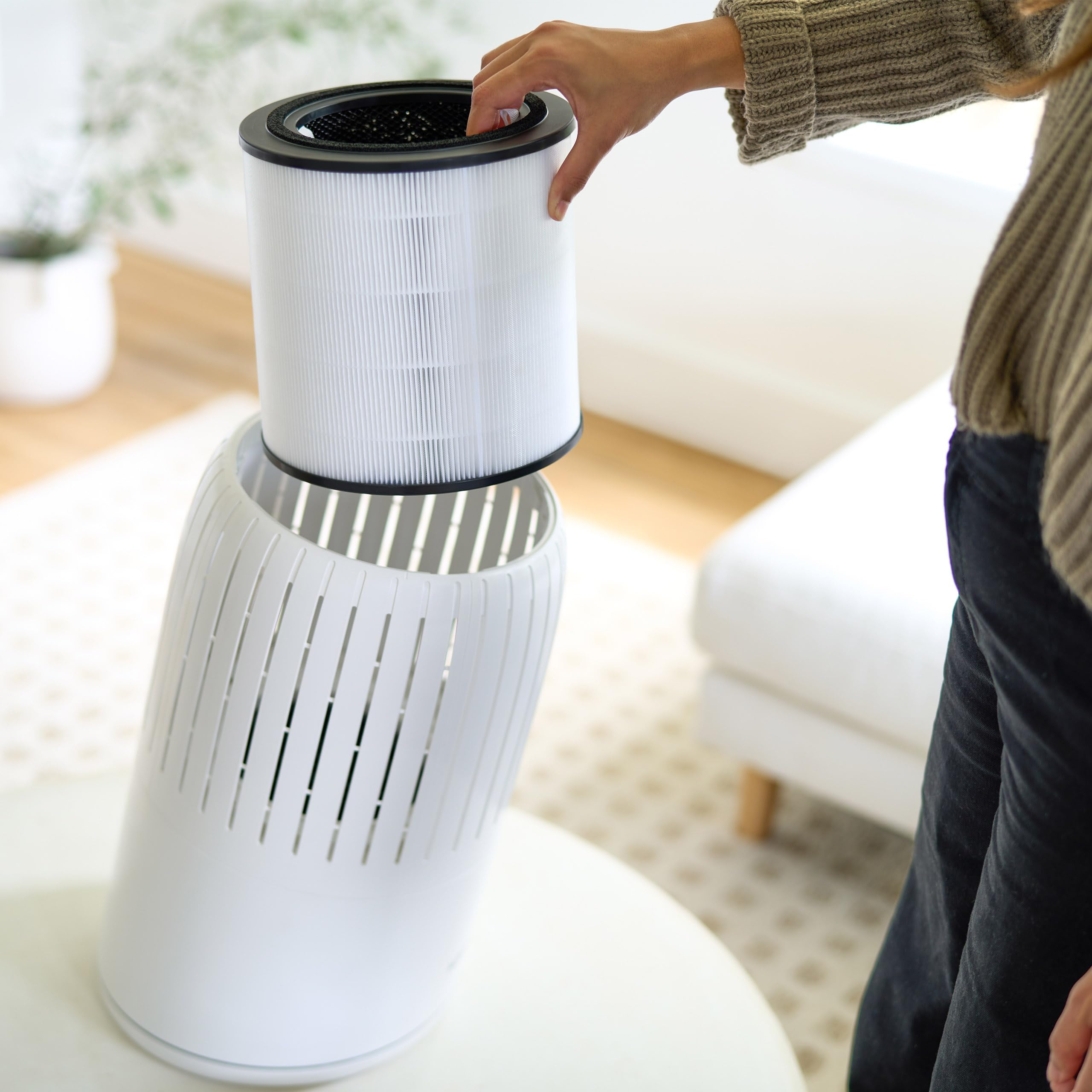 Una mano inserisce un filtro dell'aria bianco in un apparecchio bianco.