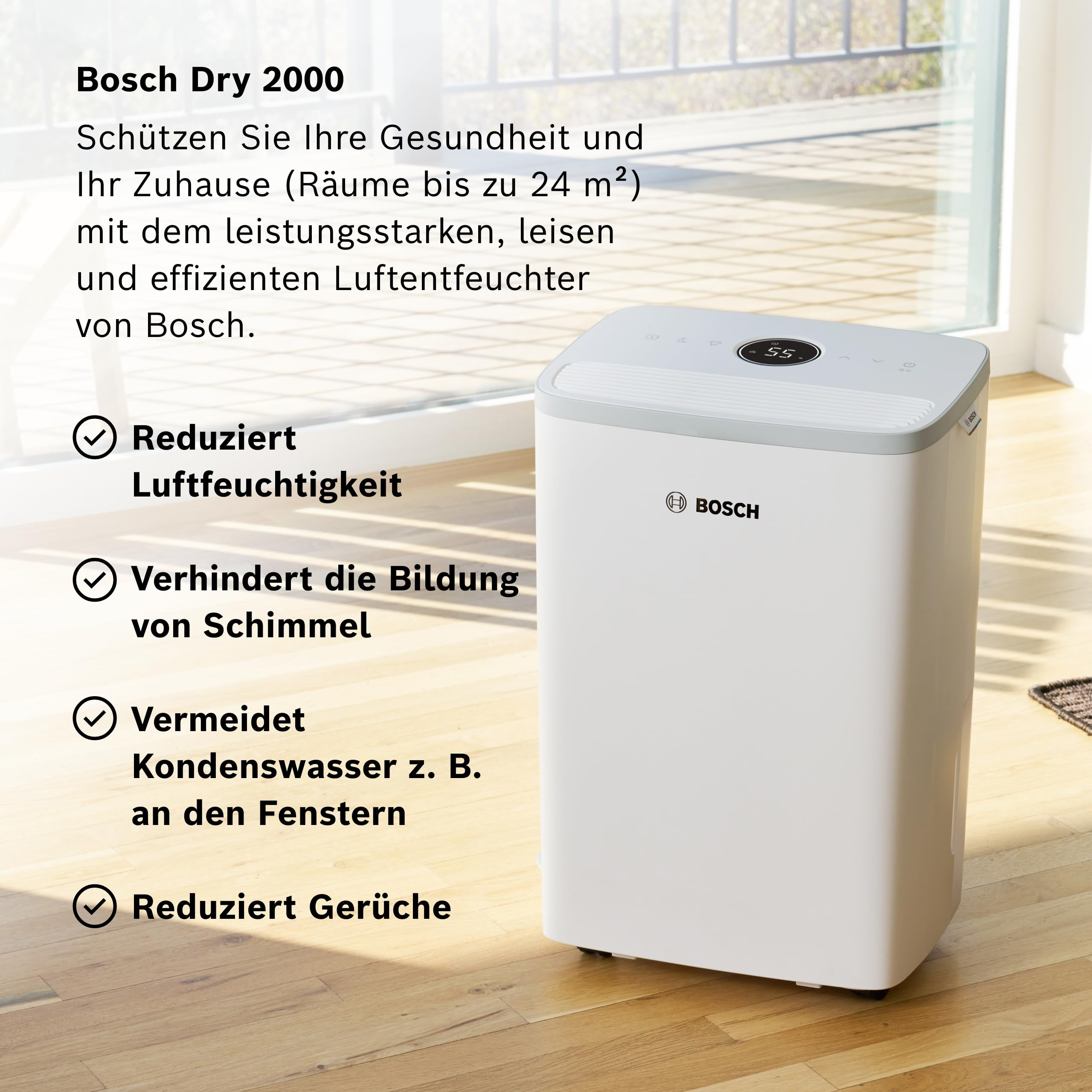 Un deumidificatore Bosch bianco è posto su un pavimento in legno accanto a una finestra.