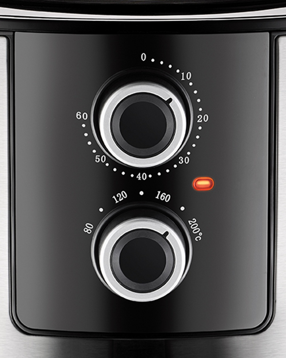 Zbliżenie czarnego panelu sterowania z dwoma pokrętłami i czerwoną lampką.