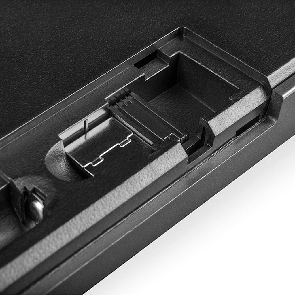 Zbliżenie czarnego plastikowego przedziału z metalowymi stykami i grzbietami.