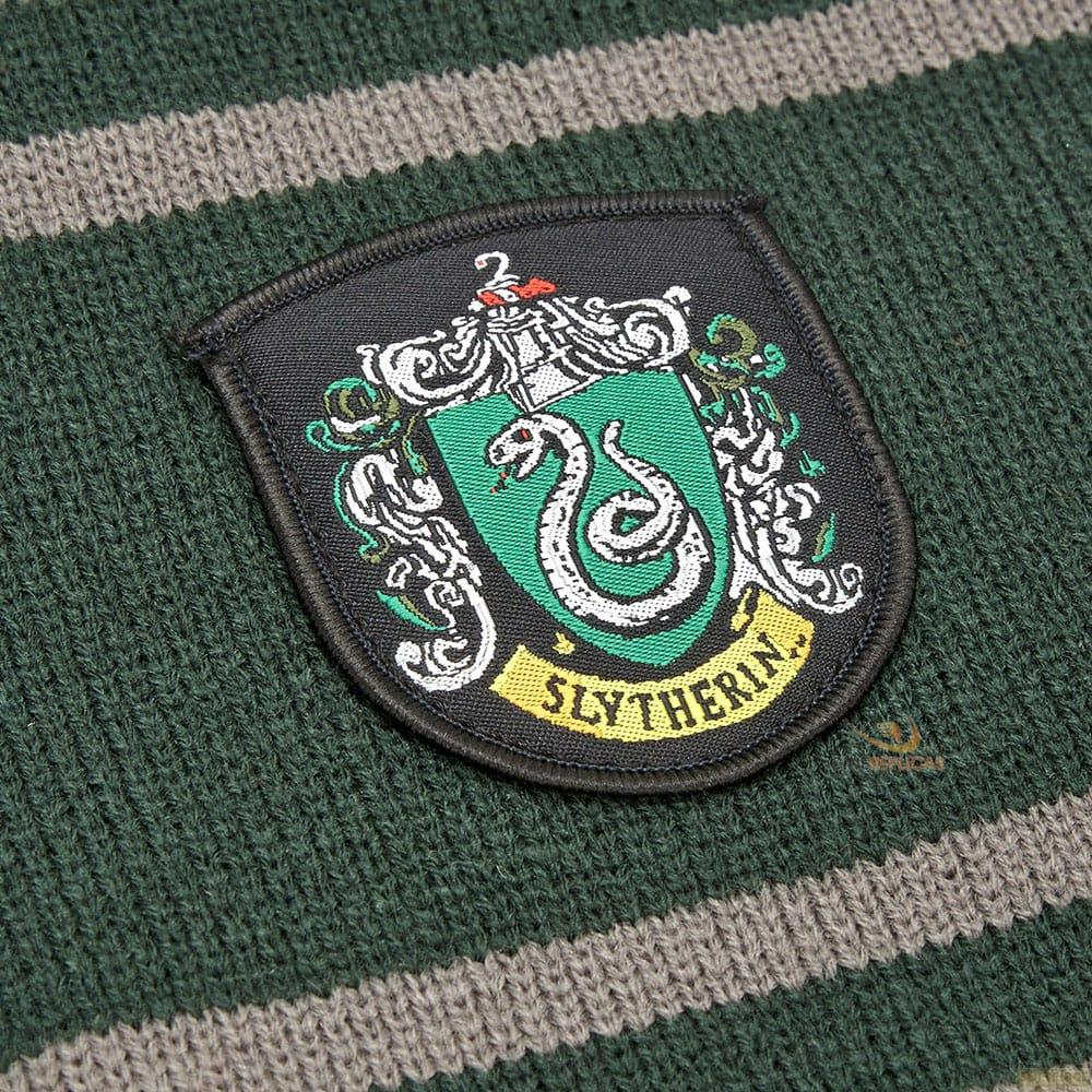Slytherin-Wappen auf grün-grau gestreiftem Strickstoff.