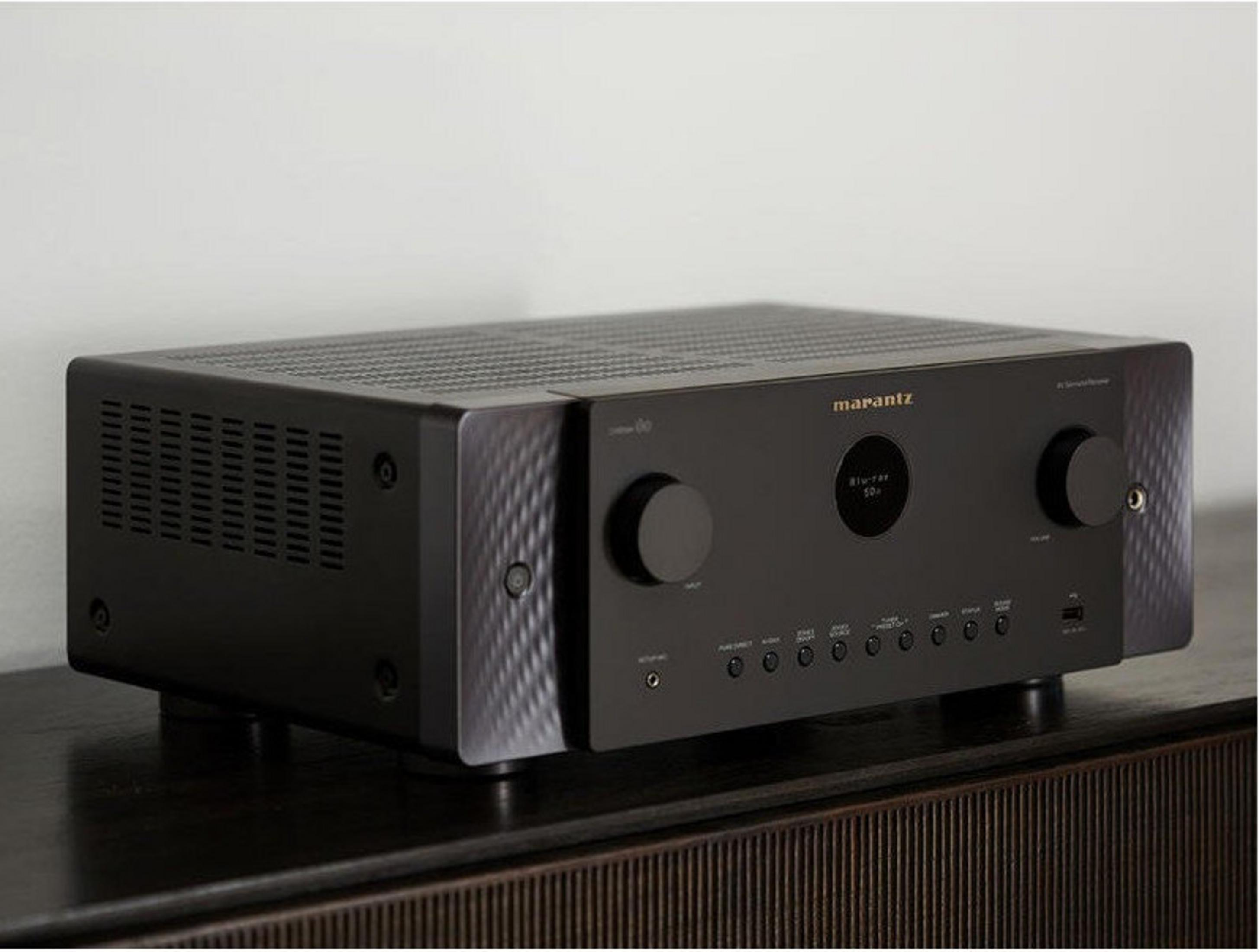 Ein schwarzer Marantz AV-Receiver steht auf einem dunklen Holzschrank. Er hat ein Digitaldisplay und Knöpfe.