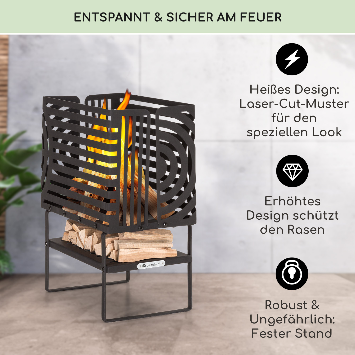 Schwarzer Metall-Feuerkorb mit geometrischem Muster, darunter Holzscheite, innen Flammen.