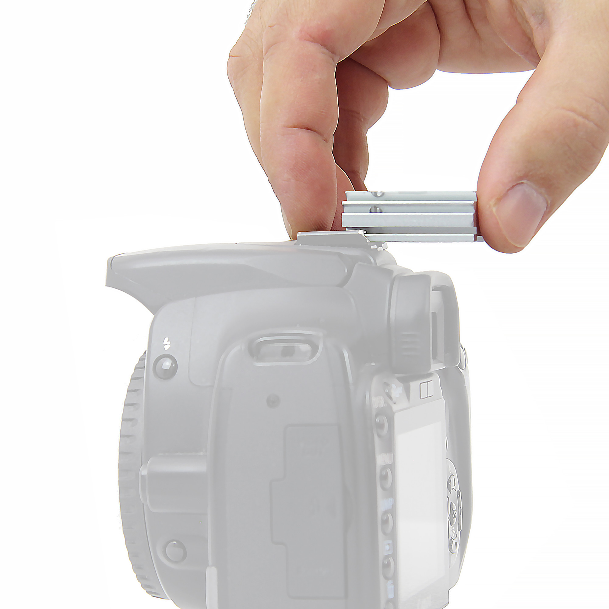 Eine Hand platziert ein silbernes Zubehör auf dem Blitzschuh einer grauen DSLR-Kamera.