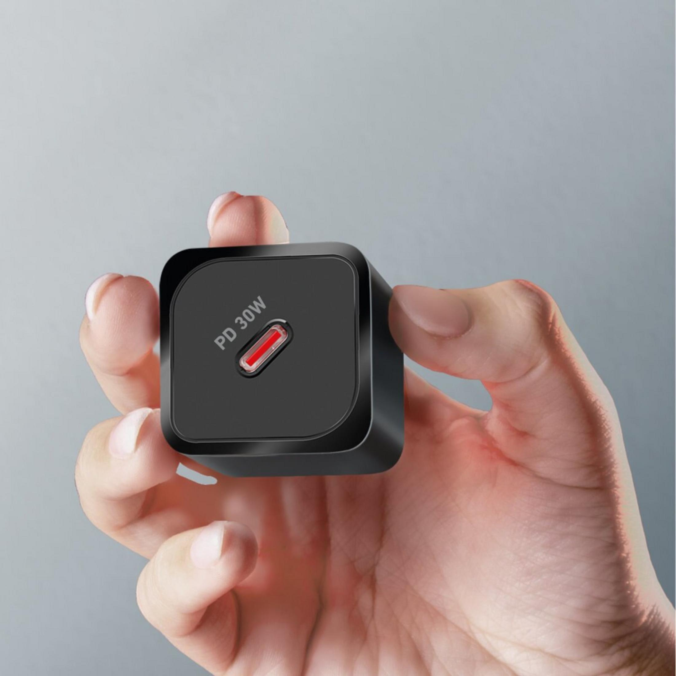 Una mano tiene un caricabatterie PD nero da 30W con porta USB-C rossa.