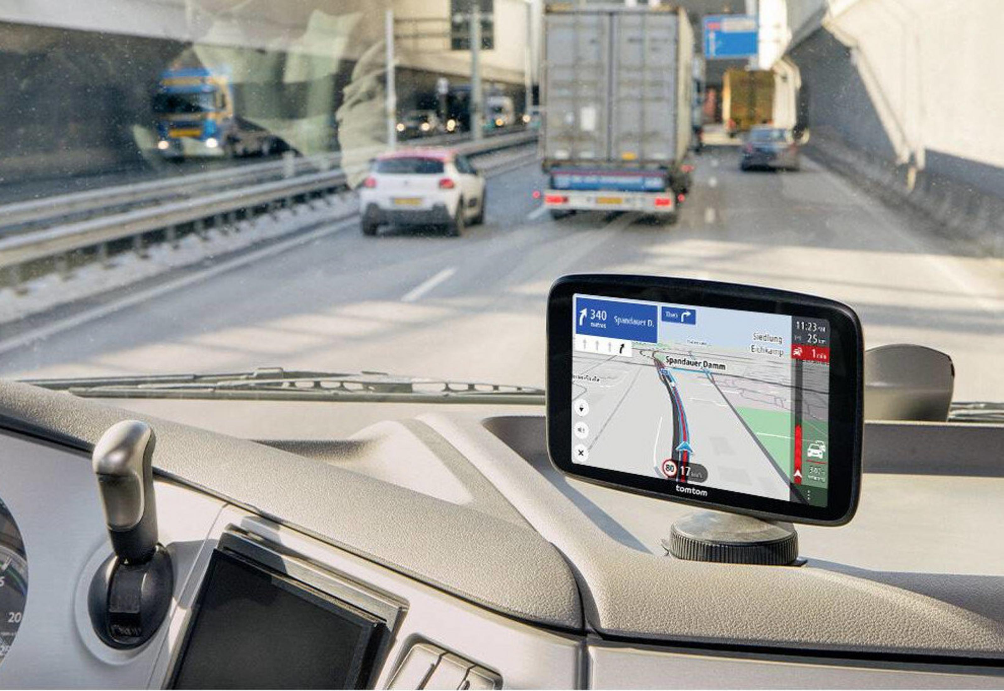GPS-Gerät im LKW zeigt eine Route an, während andere LKWs und Autos auf der Autobahn fahren.