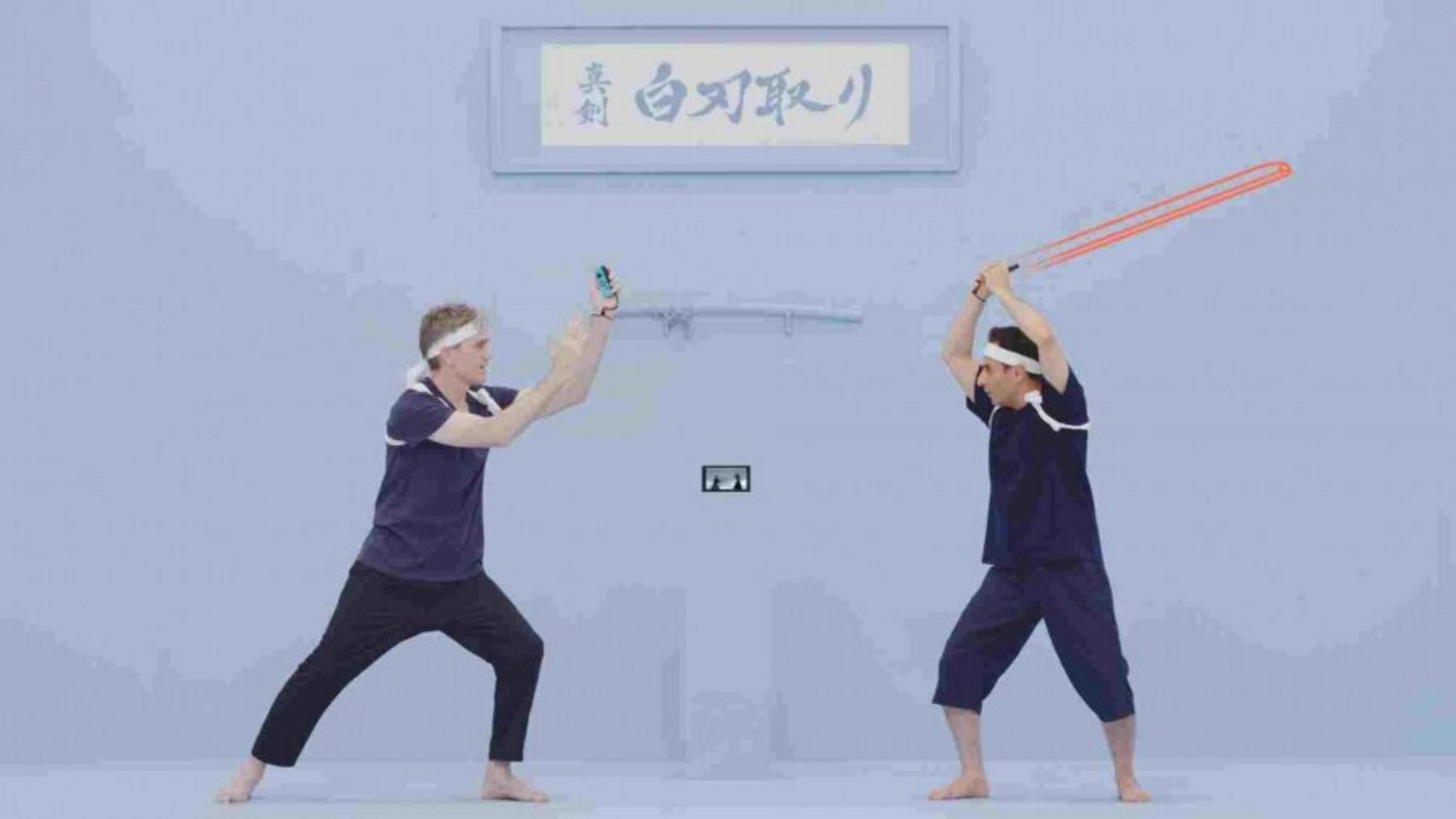 Dwóch mężczyzn w ciemnych strojach walczy świecącymi pomarańczowymi mieczami.