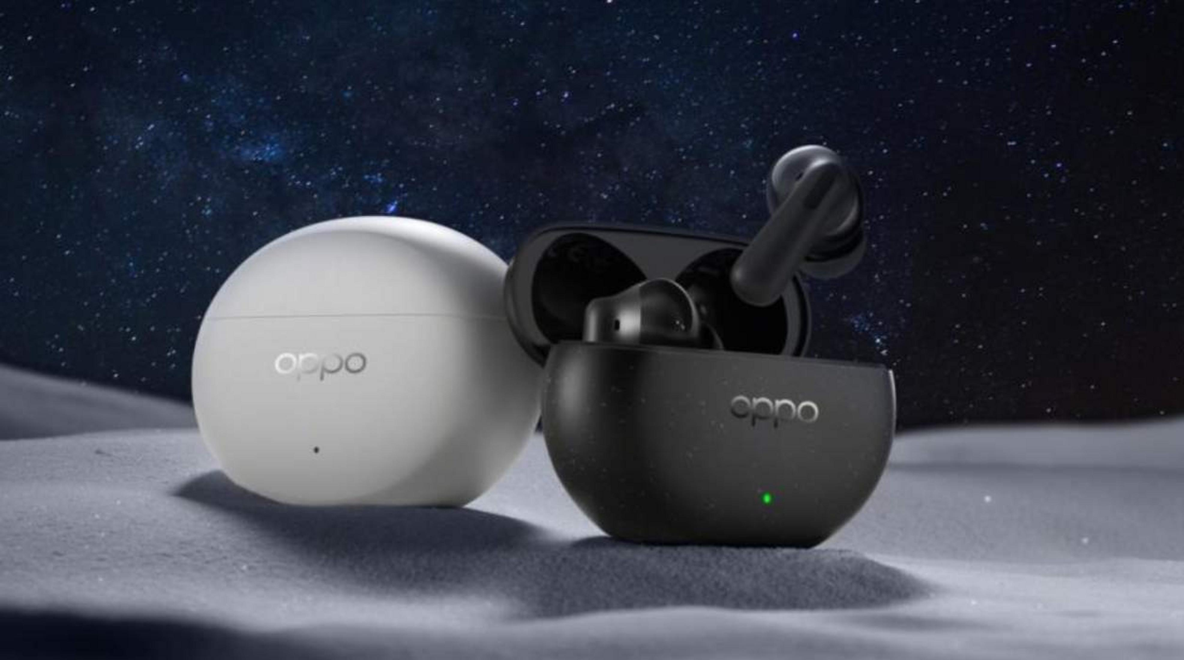 Due custodie per auricolari OPPO, una nera con auricolari, una bianca, su superficie innevata sotto cielo stellato.