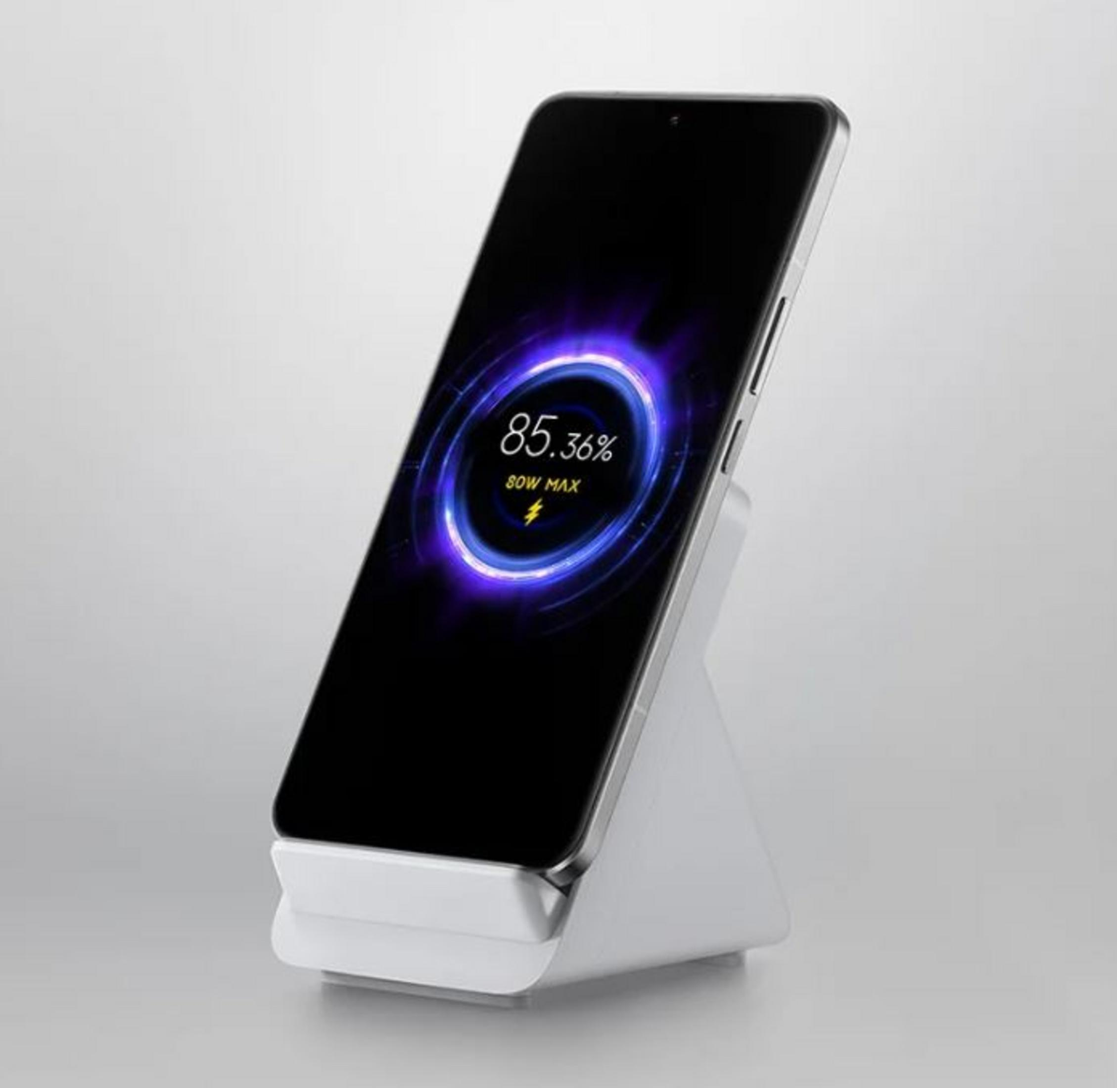 A smartphone charging on a white stand showing 85.36% and 80W MAX.