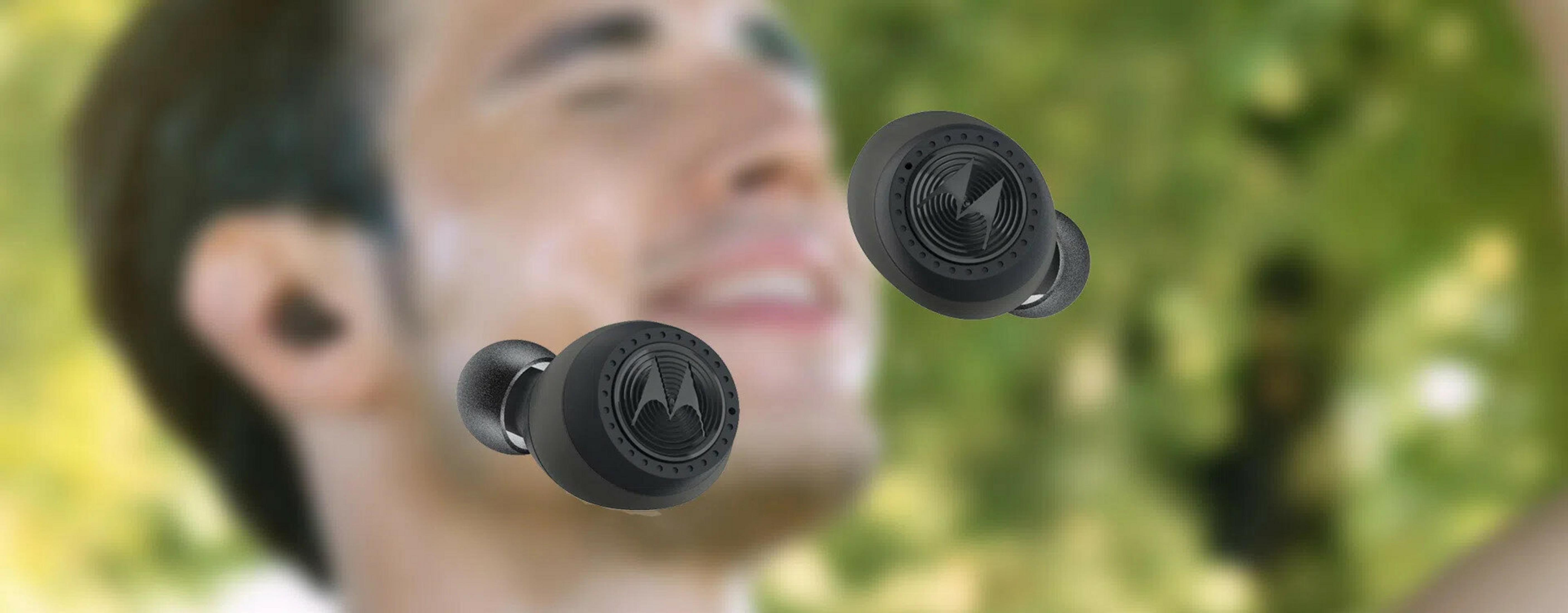 Nahaufnahme von schwarzen Motorola-Ohrhörern mit einem Mann und grünem Hintergrund.