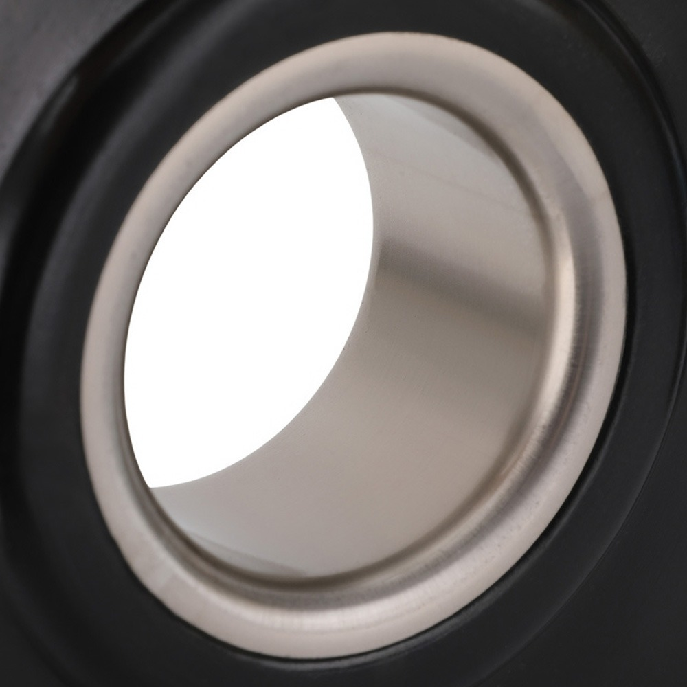 Primer plano de un altavoz negro con anillo plateado y fondo blanco.