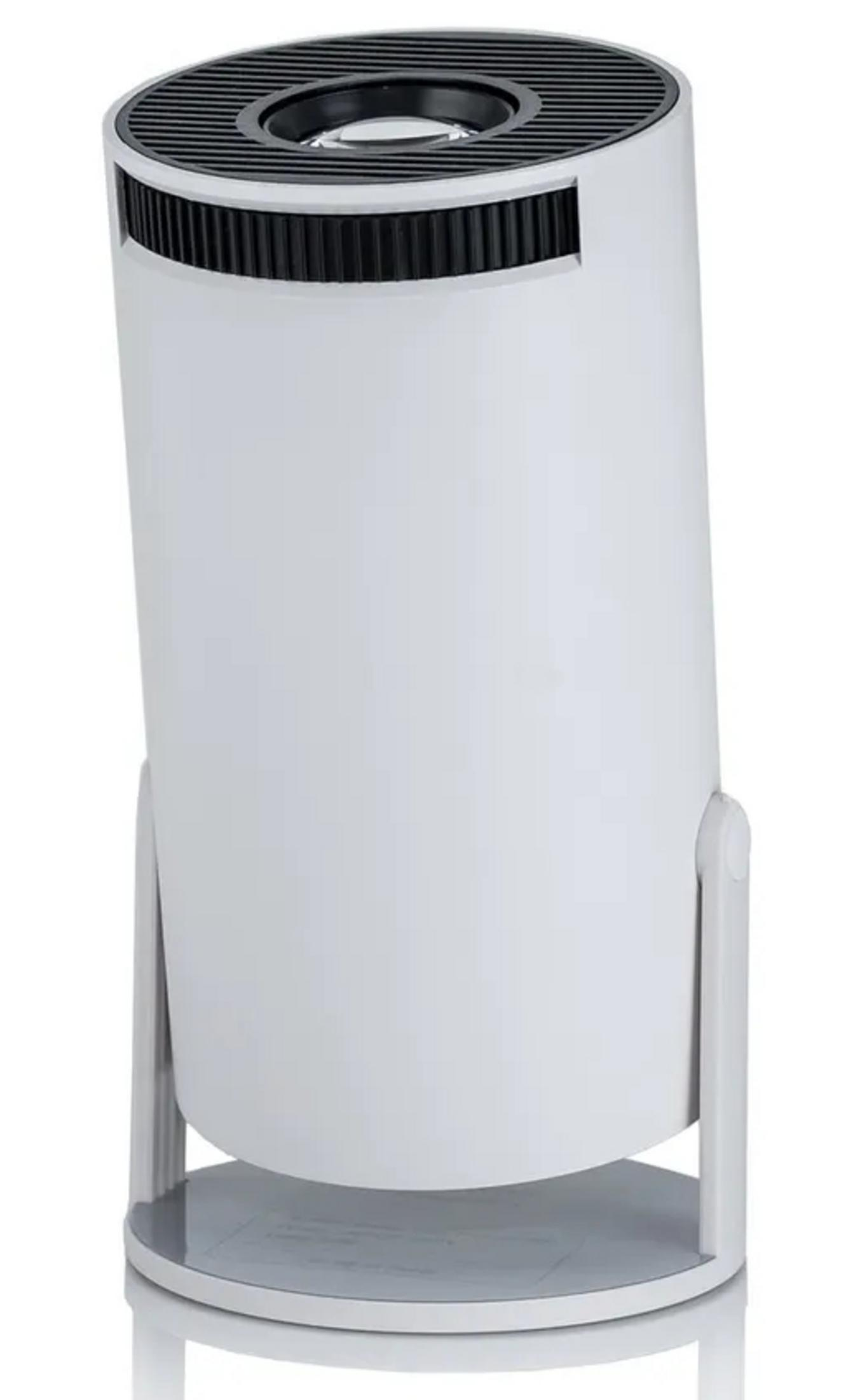 Biały cylindryczny oczyszczacz powietrza z czarnym prążkowanym blatem i srebrnymi nogami na białym tle.