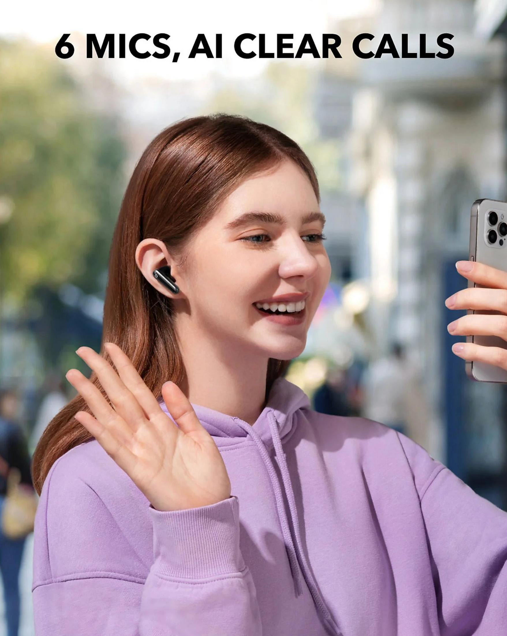 Kobieta w fioletowej bluzie macha do telefonu, nosi słuchawki. Tekst: 6 MICS, AI CLEAR CALLS.