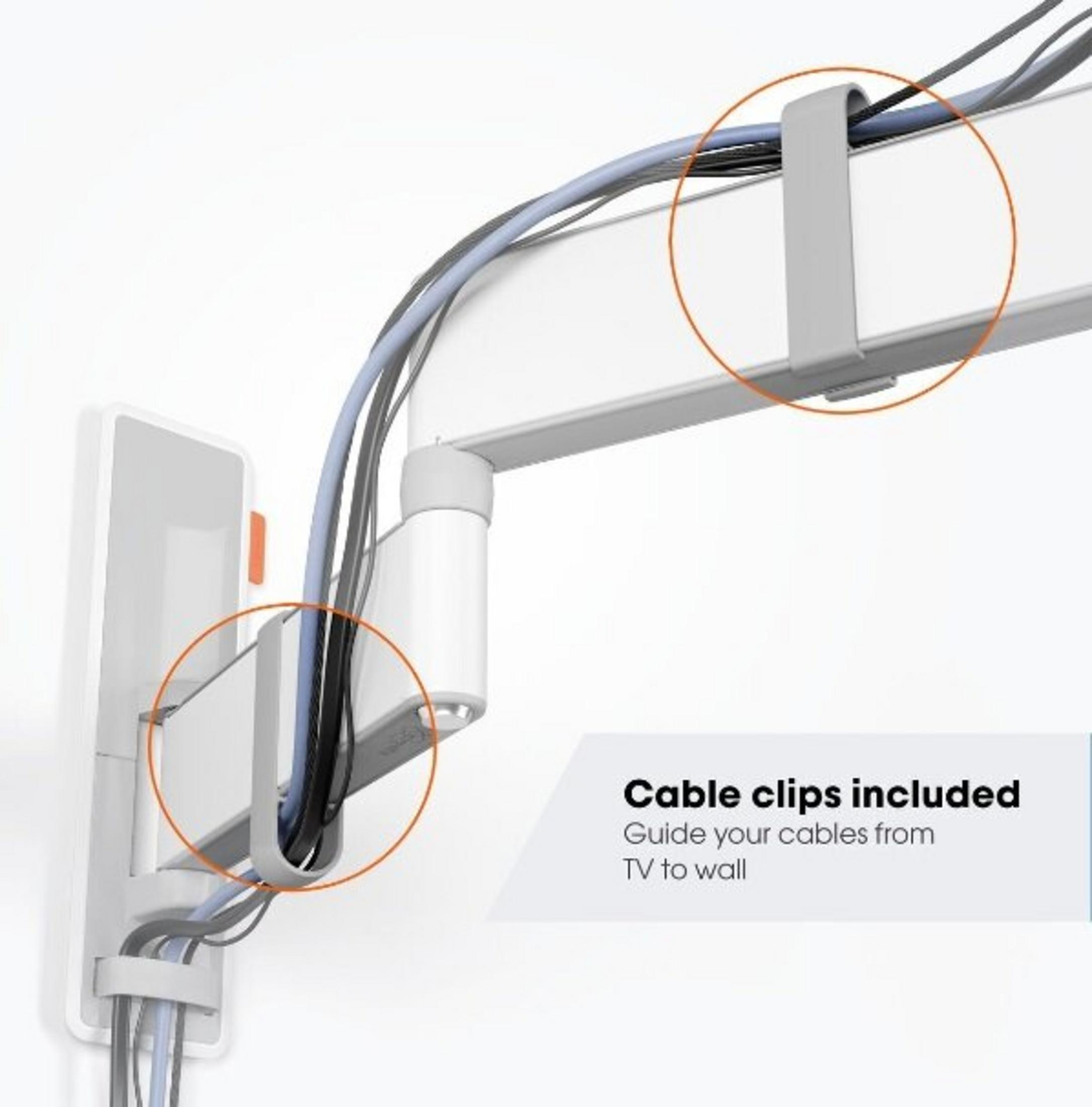 Soporte de pared blanco con clips para cables sujetando cables negros y azules.