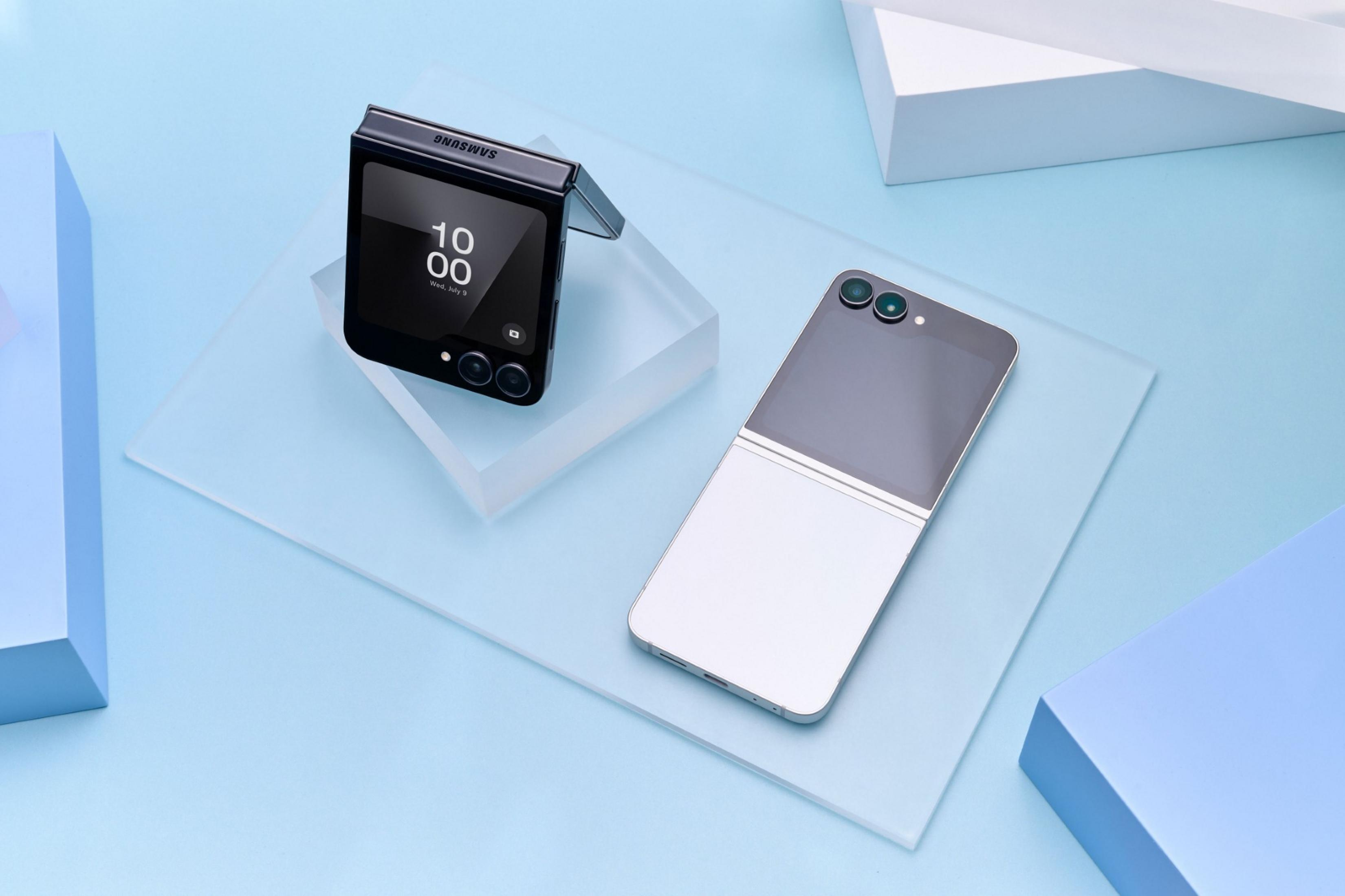 Czarny telefon z klapką leży obok srebrno-szarego telefonu z klapką.