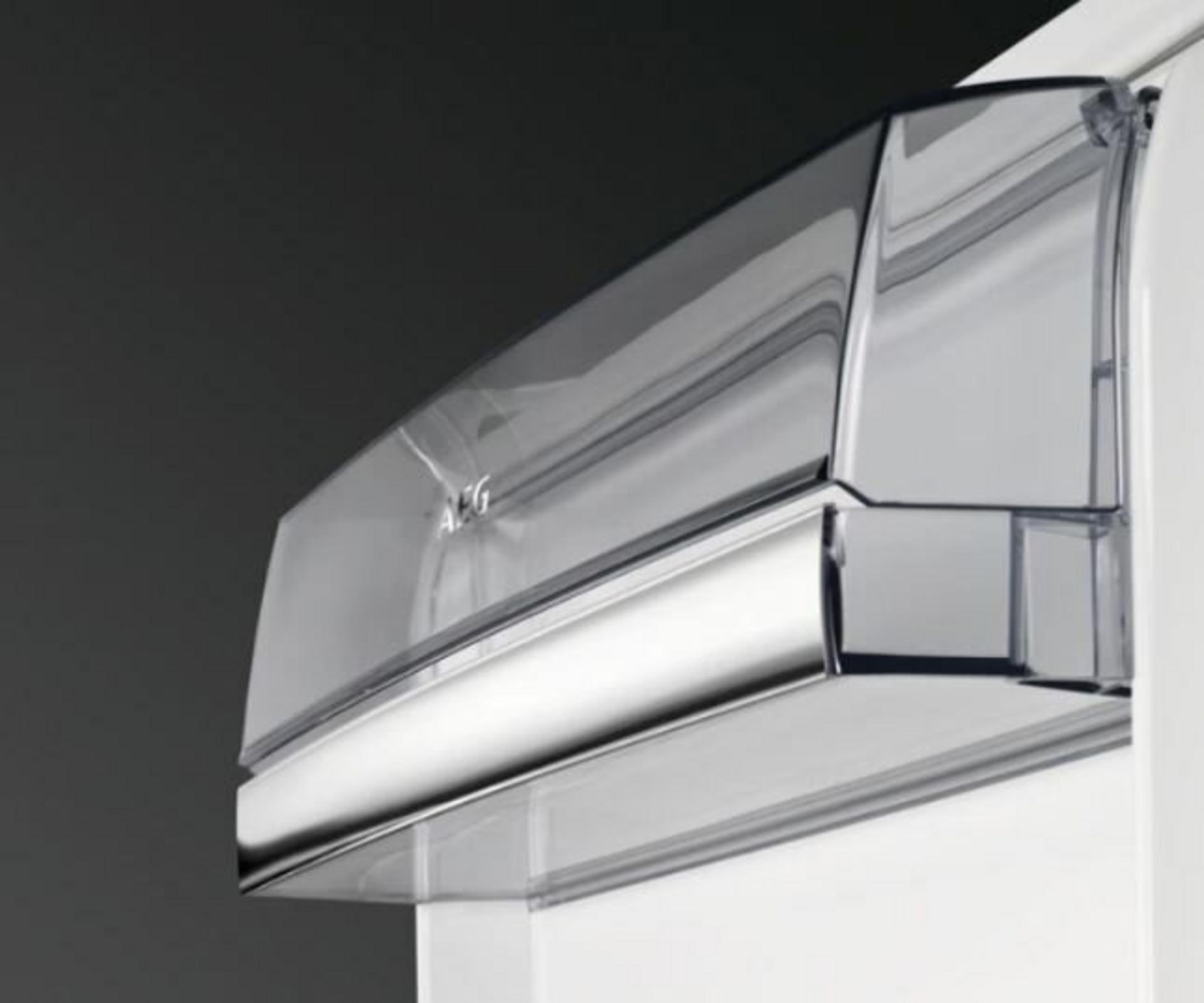 Primer plano de un compartimento transparente de refrigerador con logo AEG.