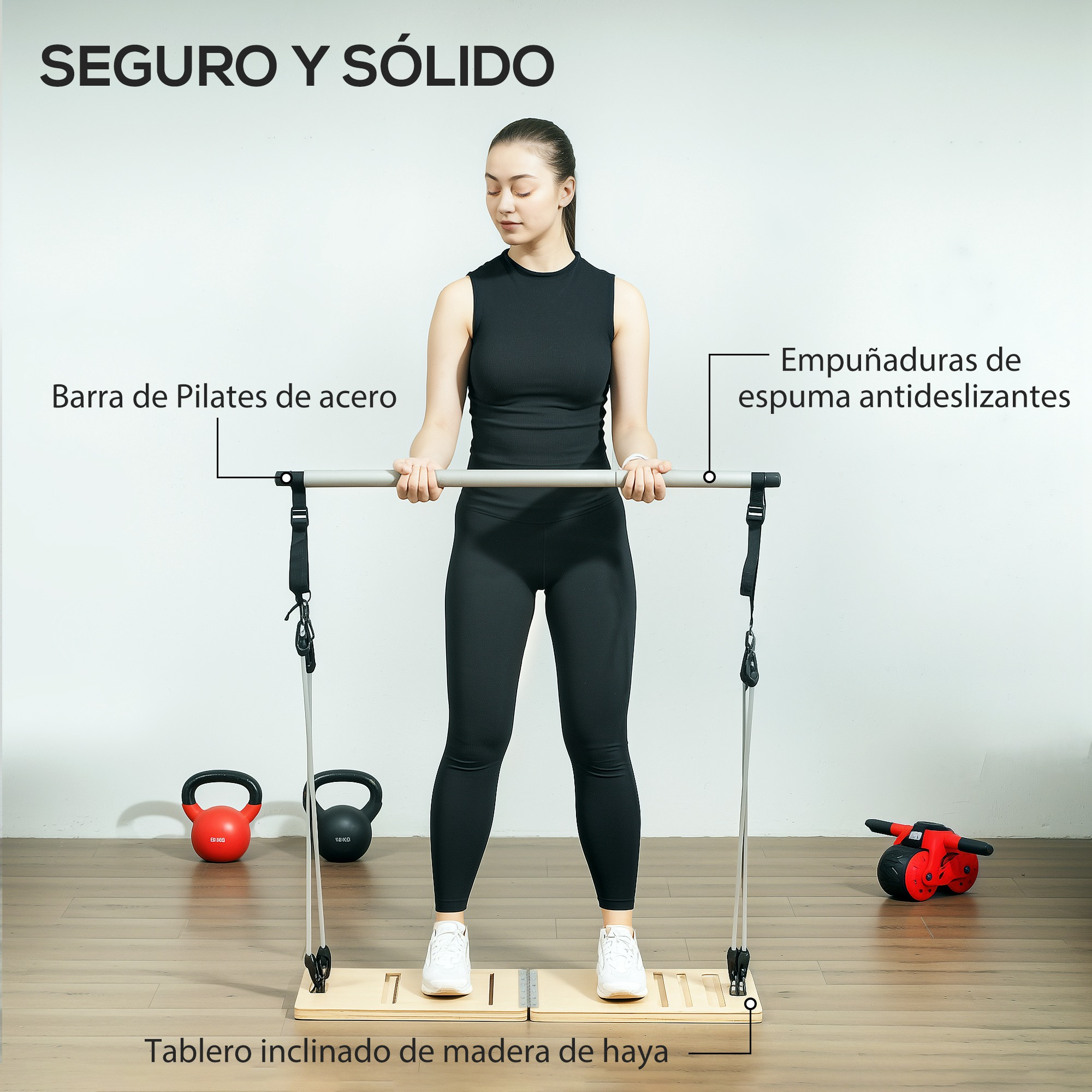 Mujer usando una barra de Pilates con agarres de espuma en una plataforma de madera. Mancuernas rojas y negras cerca.