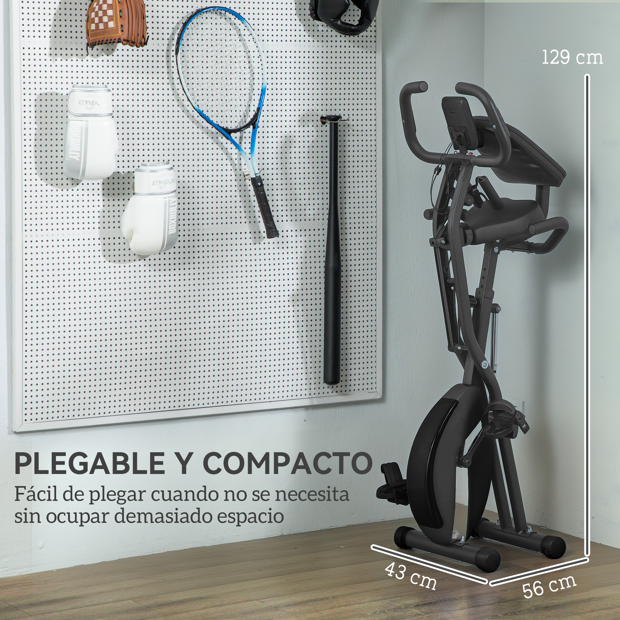 Bicicleta estática junto a pared con equipo deportivo. Medidas 129x56x43 cm.
