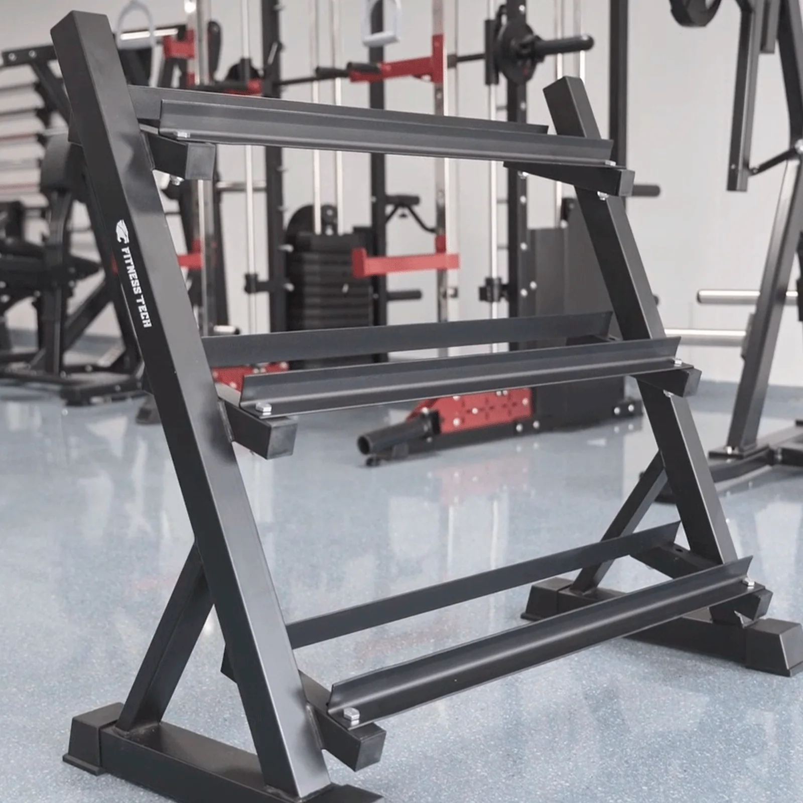 Un soporte negro para mancuernas de tres niveles en un gimnasio.