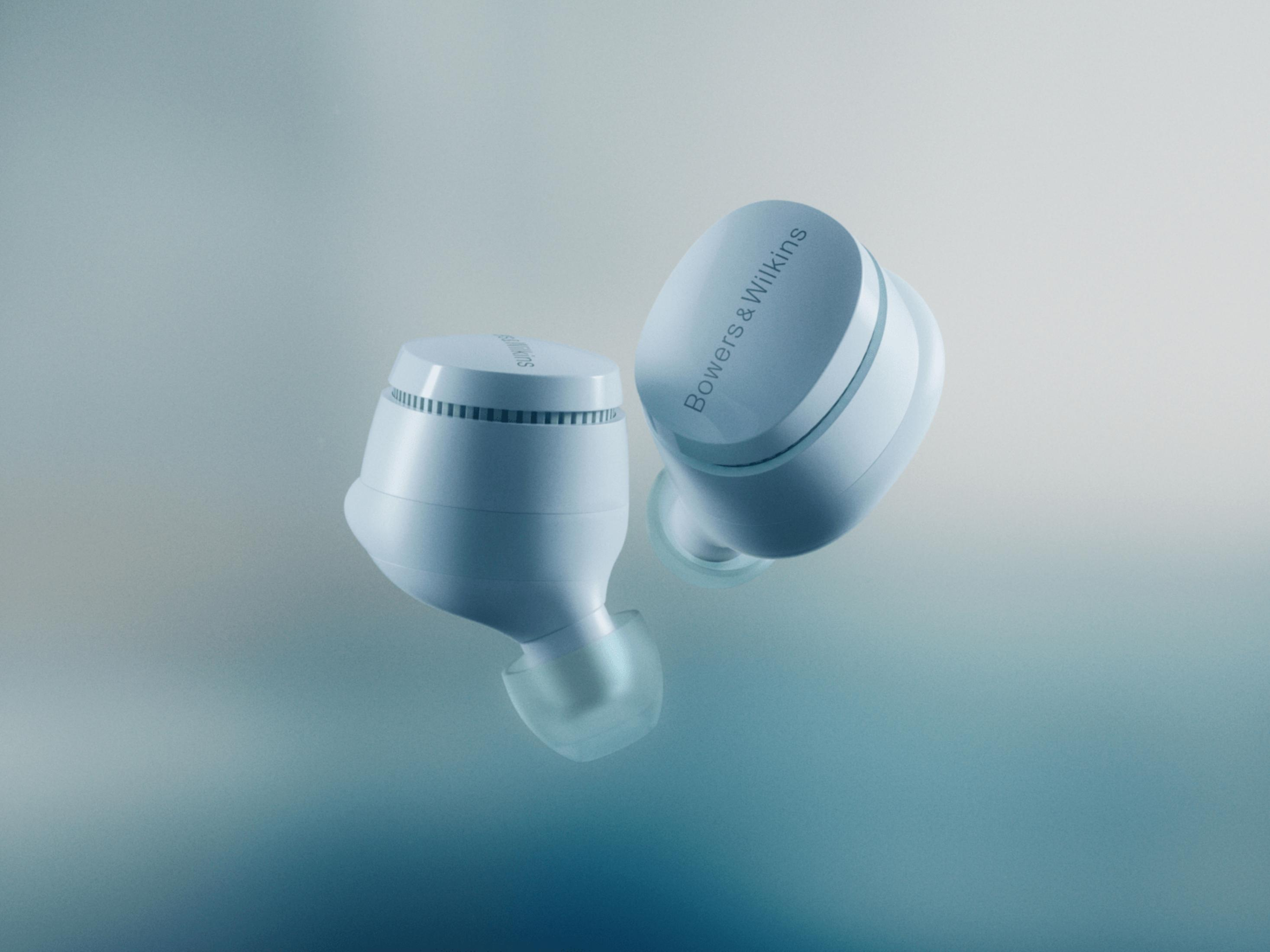 Zwei hellblaue Bowers & Wilkins Ohrhörer schweben vor einem weichen blauen Farbverlauf.