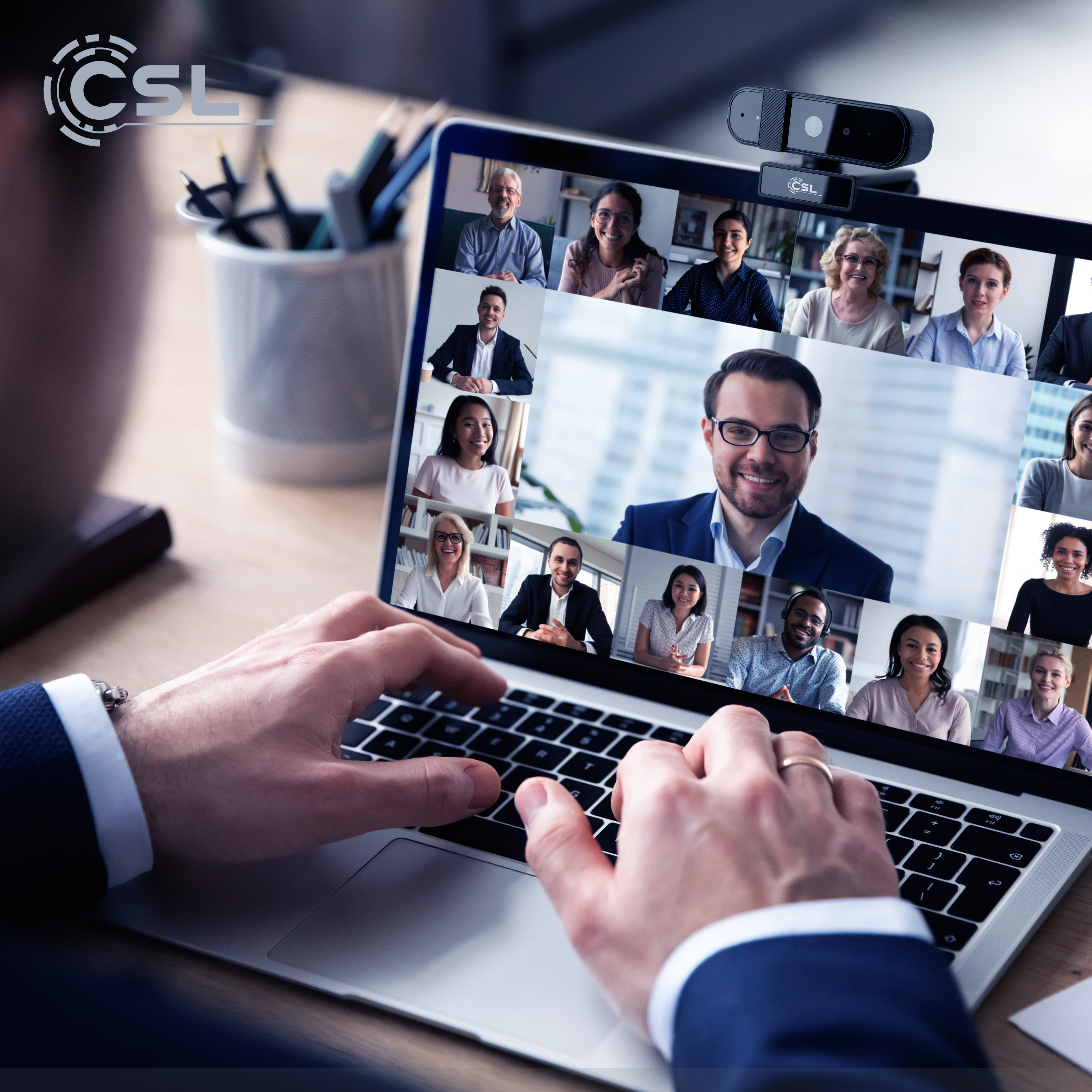 Eine Person tippt auf einem Laptop, auf dem ein Videoanruf mit vielen Personen läuft.