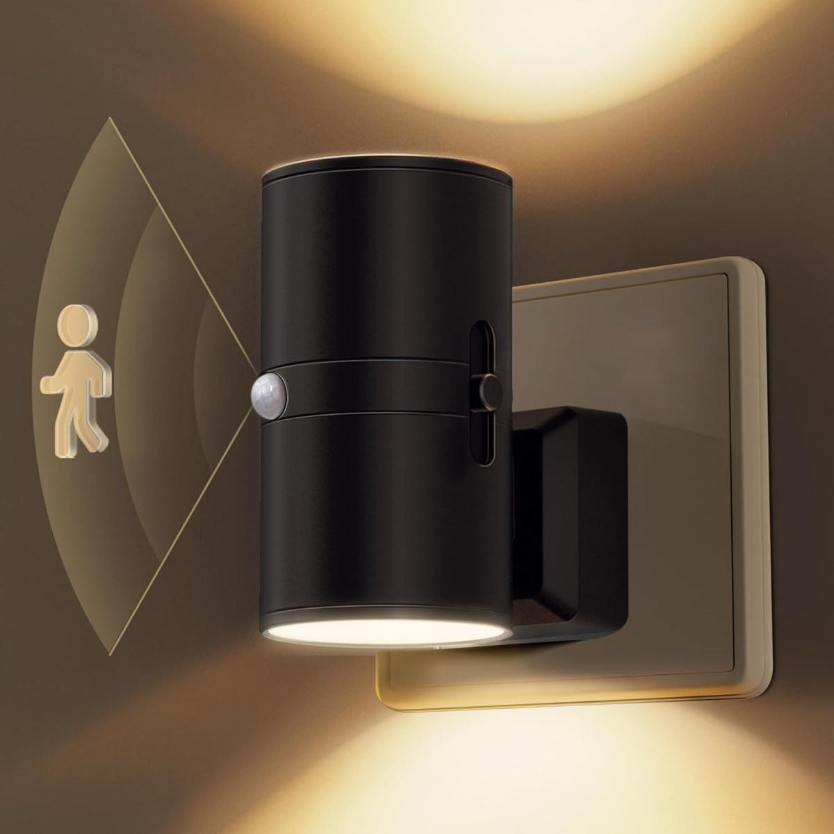 Ein schwarzes, bewegungsaktiviertes Licht mit Sensor ist an einer Steckdose montiert.