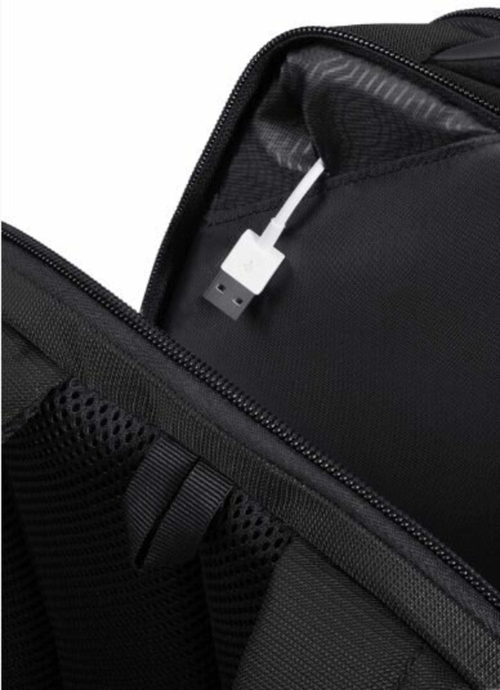 Ein weißer USB-Stecker ragt aus einem schwarzen Rucksack.