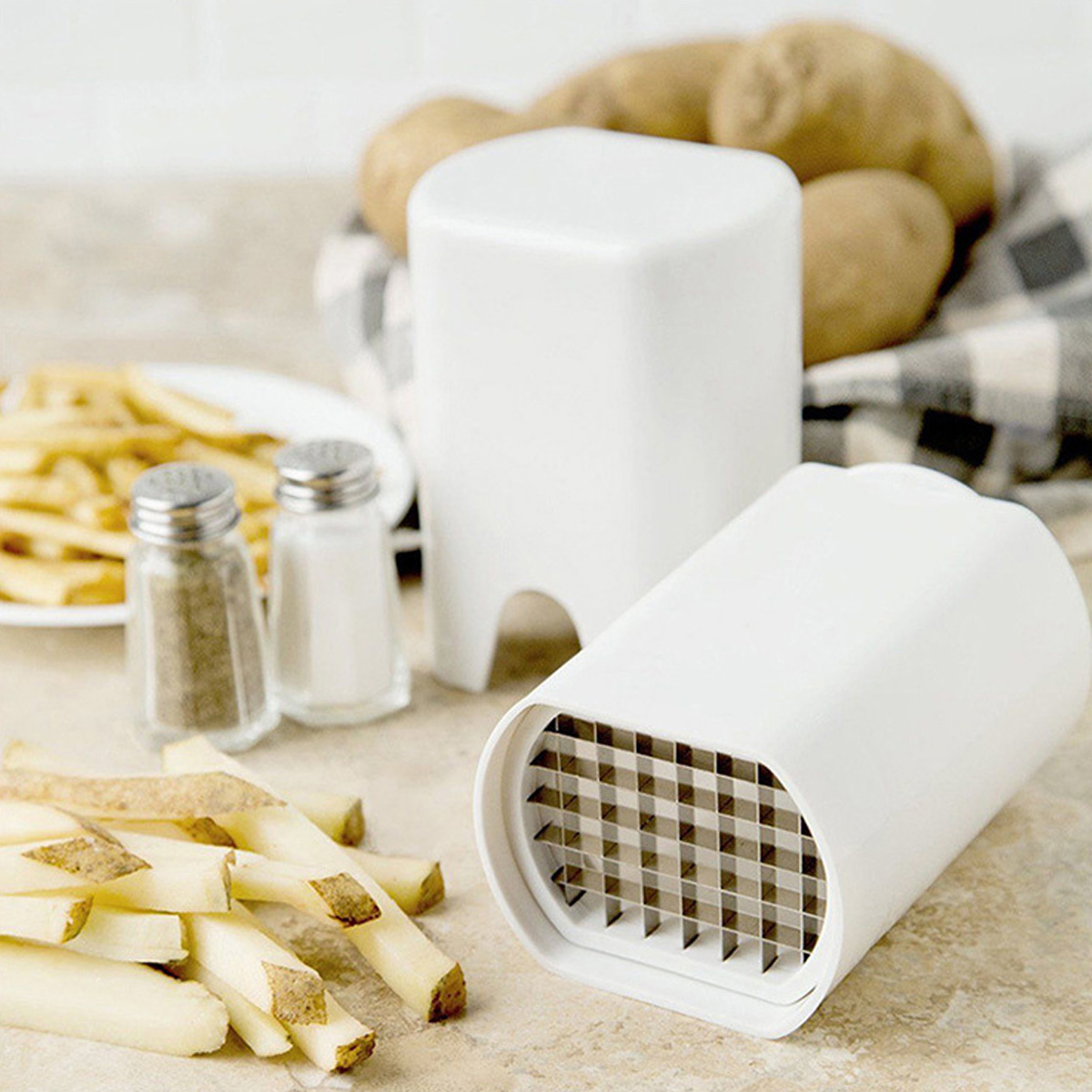 Weiße Pommes-Schneider, Kartoffeln und Gewürze auf einer Theke.