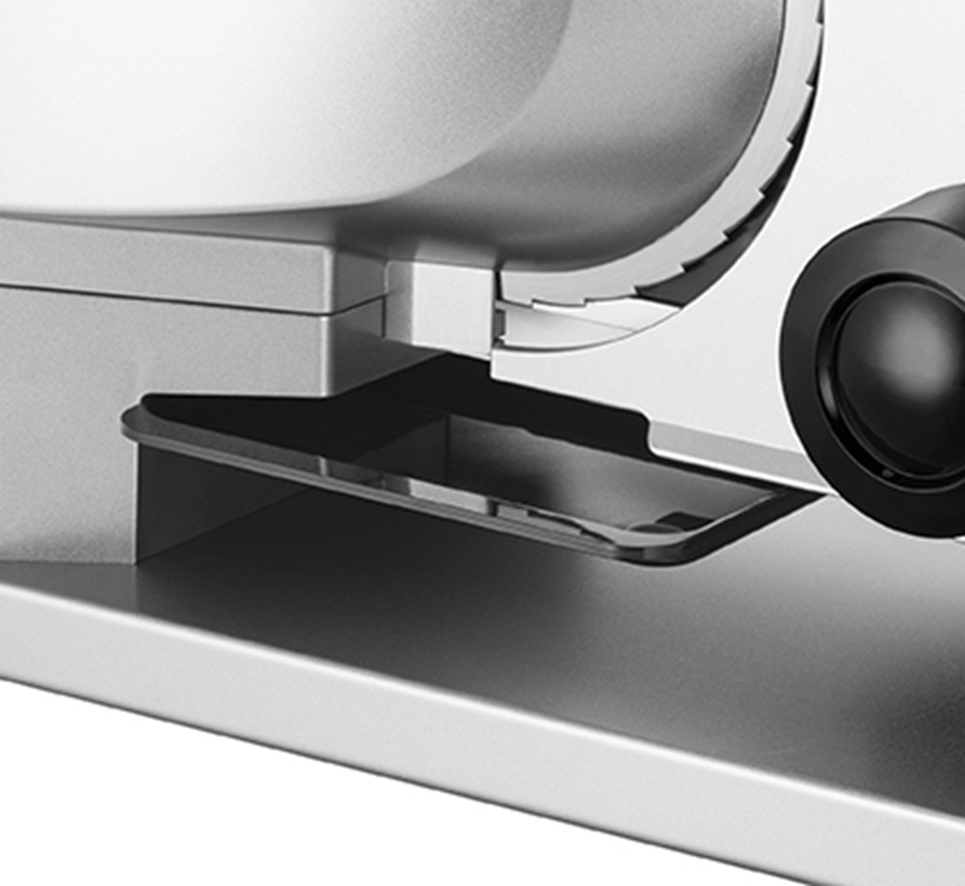 Zbliżenie srebrnego urządzenia z ząbkowanym kołem i czarnym pokrętłem.