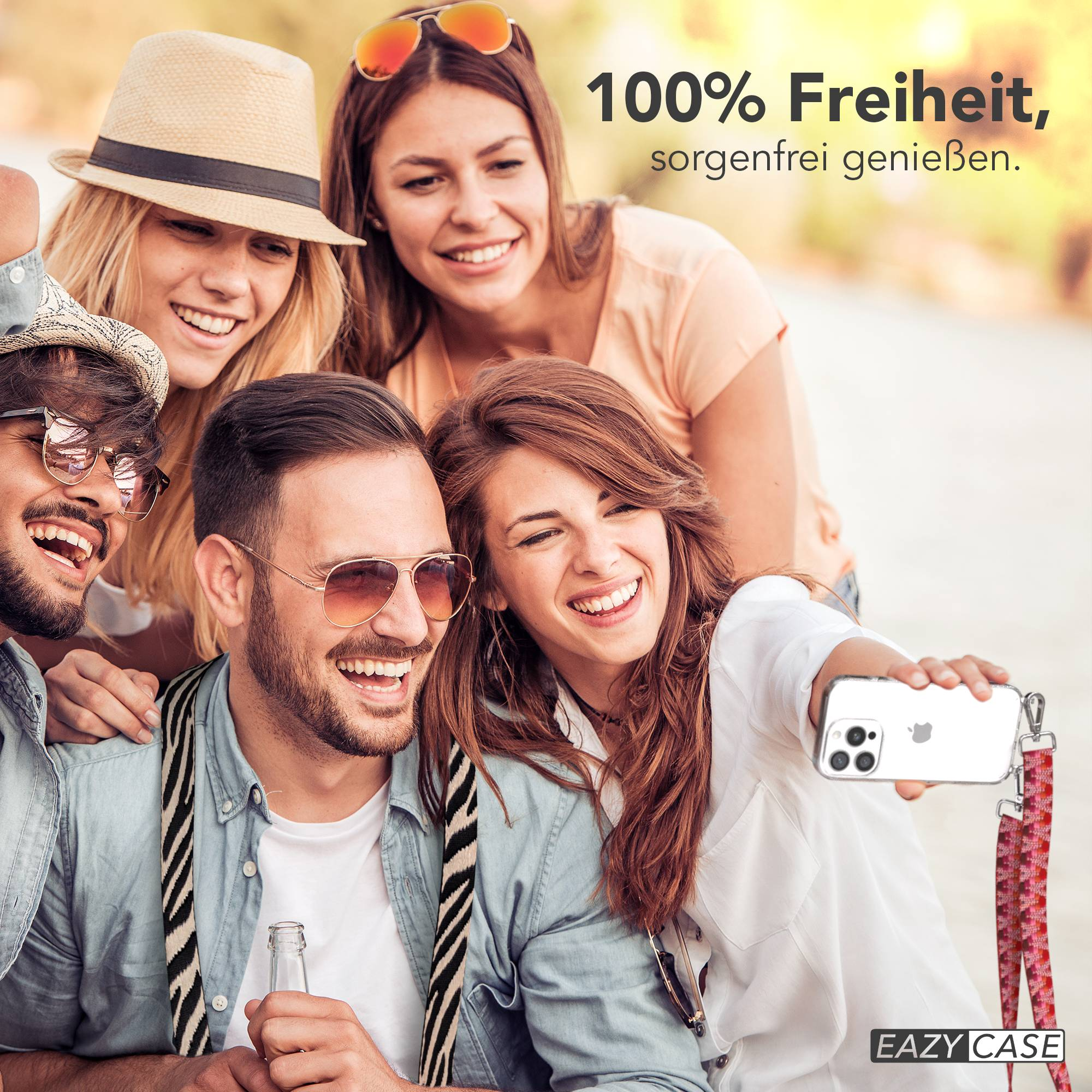 Vier lachende Freunde machen ein Selfie mit einem Handy, eine Frau hält es.