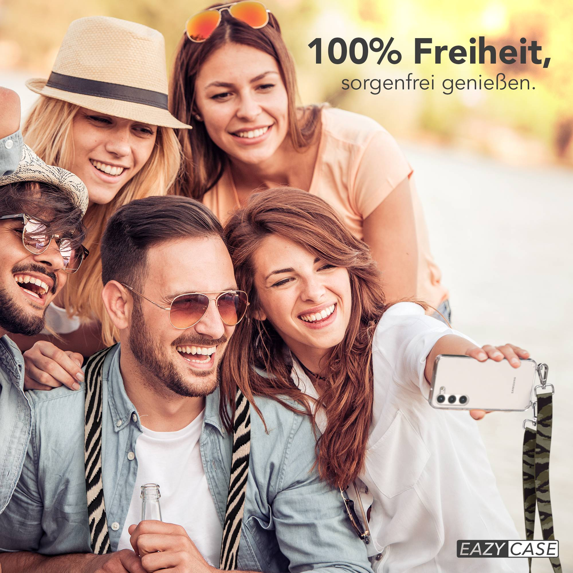 Vier lachende Freunde machen ein Selfie mit einem Handy, das an einer Tarnschnur hängt.