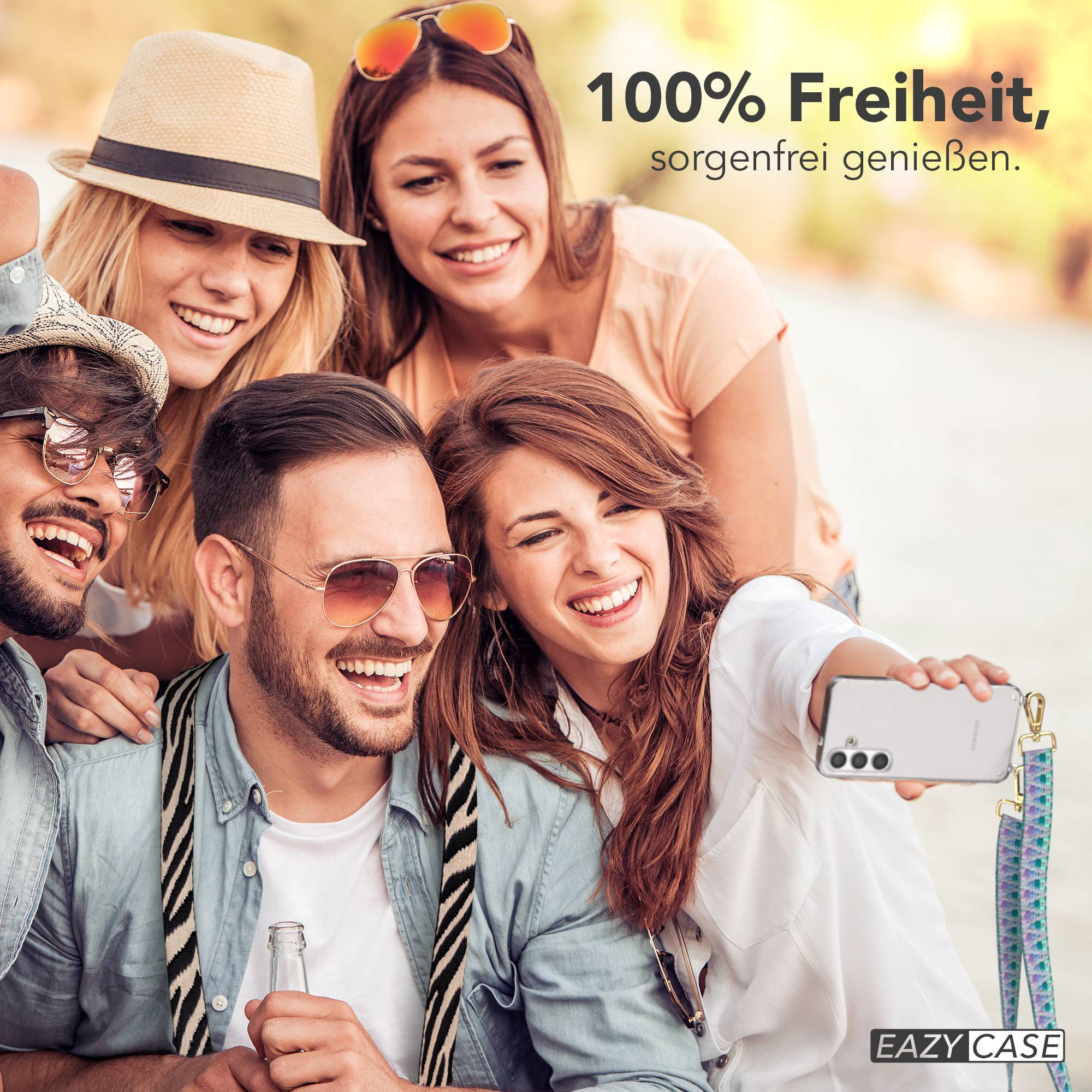 Vier Freunde machen draußen ein Selfie und lächeln glücklich. Einer hält ein Handy.