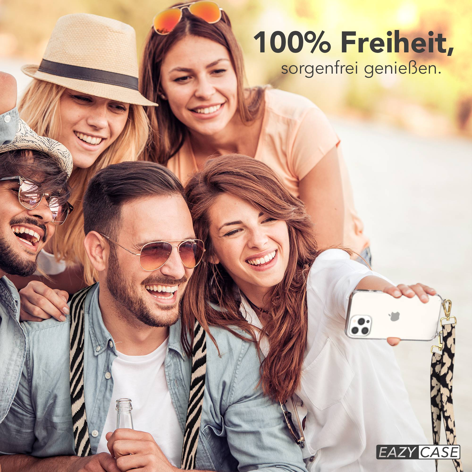 Vier Freunde machen draußen ein Selfie und lächeln. Einer hält ein Handy und eine Flasche.