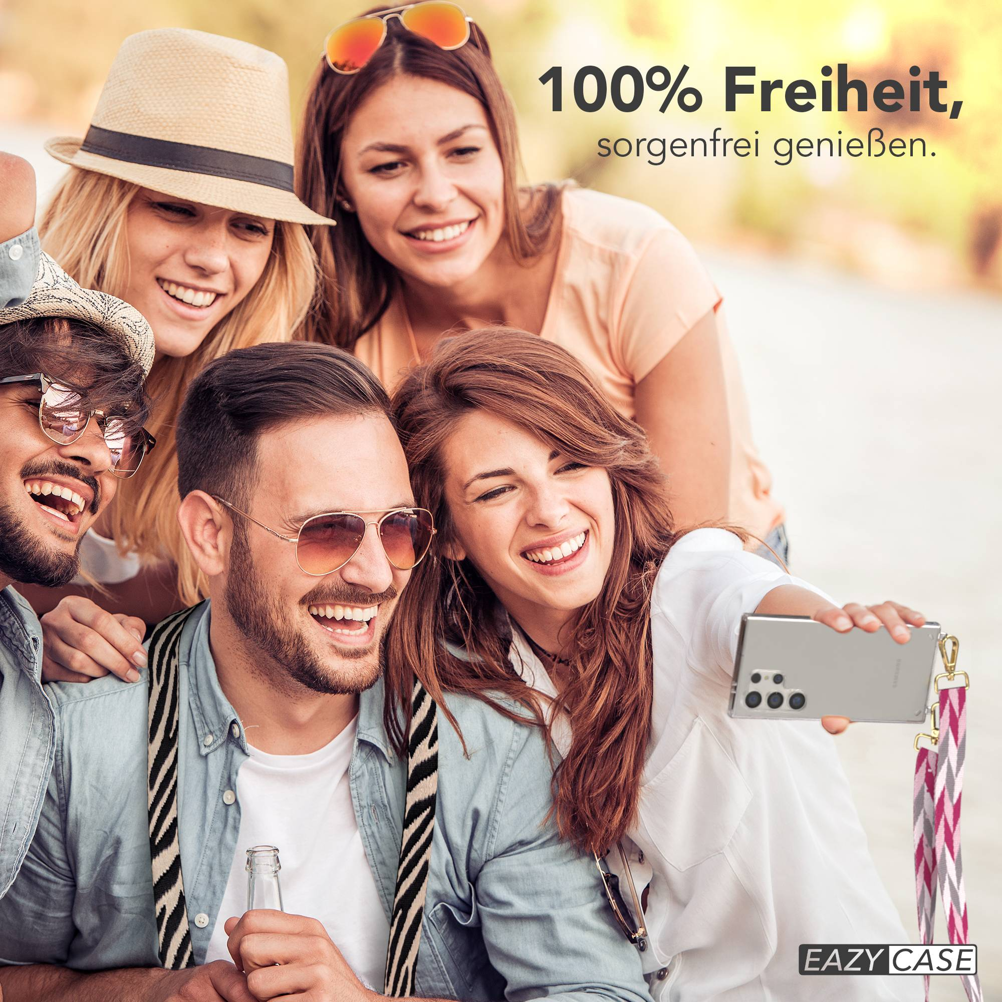 Freunde machen draußen ein Selfie und lächeln. Einer hält ein Handy und eine Flasche.