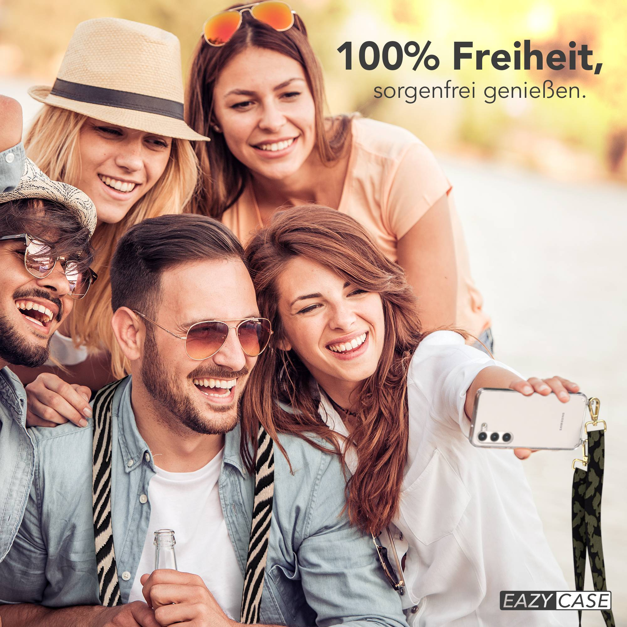 Vier lächelnde Freunde machen ein Selfie. Einer hält ein Handy, ein anderer eine Flasche.